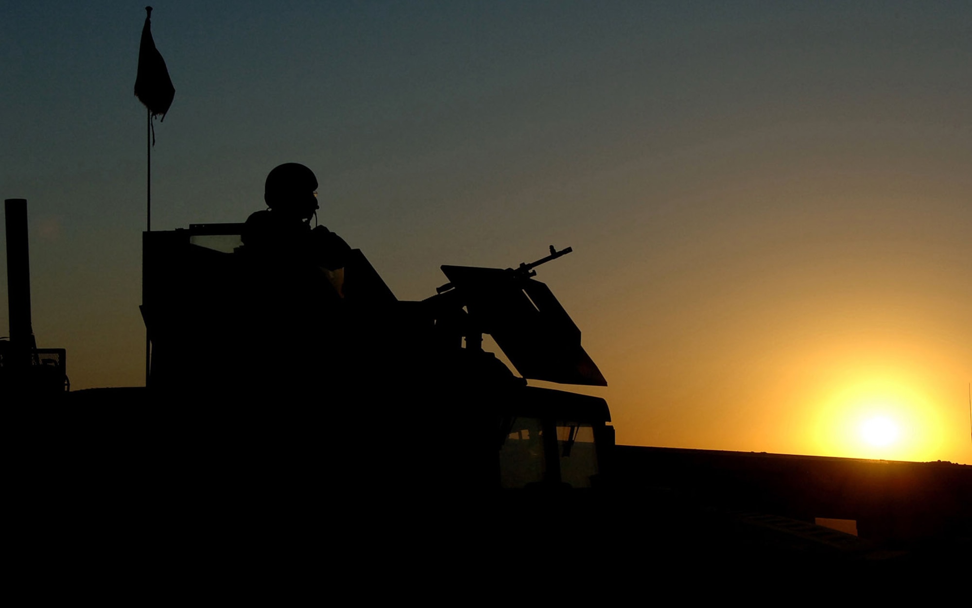 RED HORSE personnel are trained and equipped to defend themselves on deployments. Here, Staff Sgt. Luke Oaks provided security on Contingency Operating Base Speicher at Tikrit, Iraq, as his convoy prepared to return to Forward Operating Base Marez after transporting construction supplies September 2006. Oak was with the 557th Expeditionary RED HORSE Squadron. (U.S. Air Force photo)