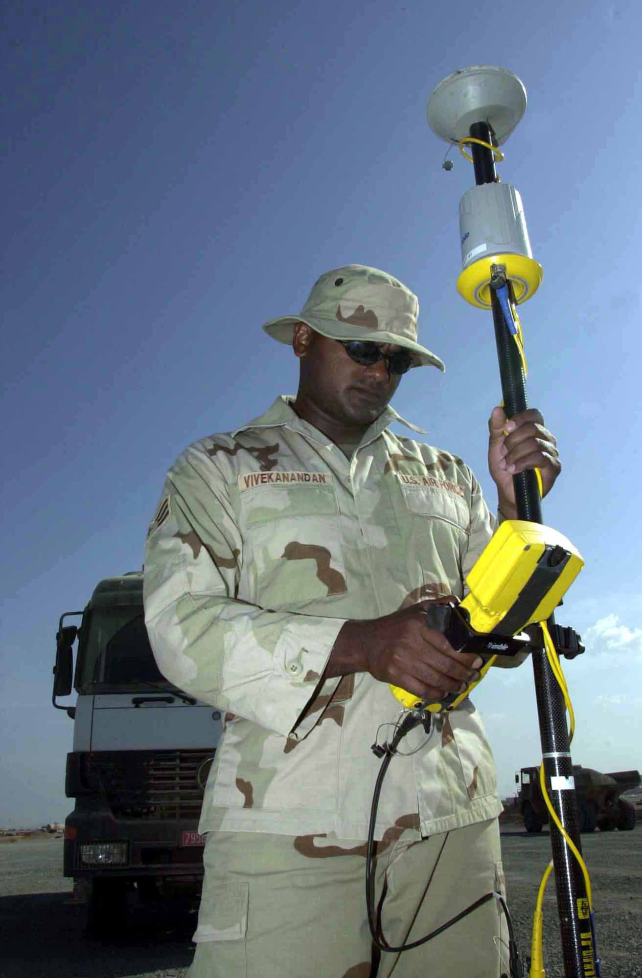 Senior Airman Pratt Vivekanandan, an engineering journeyman with the 819th/219th Expeditionary RED HORSE Squadrons (ERHS), uses a global positioning system (GPS) rover and data collector to check the elevation during a runway construction project in support of Operation Enduring Freedom. (U.S. Air Force photo)