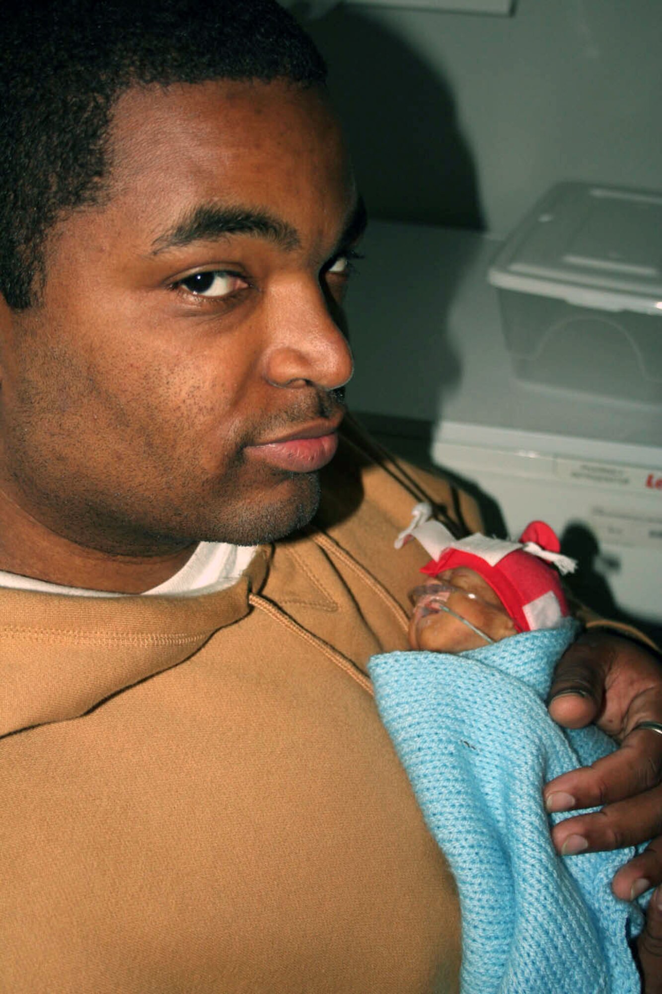 Tech. Sgt. Barry Frazier holds his premature son, Eric LeVon Frazier, in November at Norfolk and Norwich Hospital in England. Born Sept. 6, almost four months prematurely, Eric and his twin sister stayed in a local British hospital on the neonatal intensive care ward. Eric passed away Dec. 10. Sergeant Frazier is assigned to the 100th Air Refueling Wing Legal Office at Royal Air Force Base Mildenhall, England. (Courtesy photo) 
