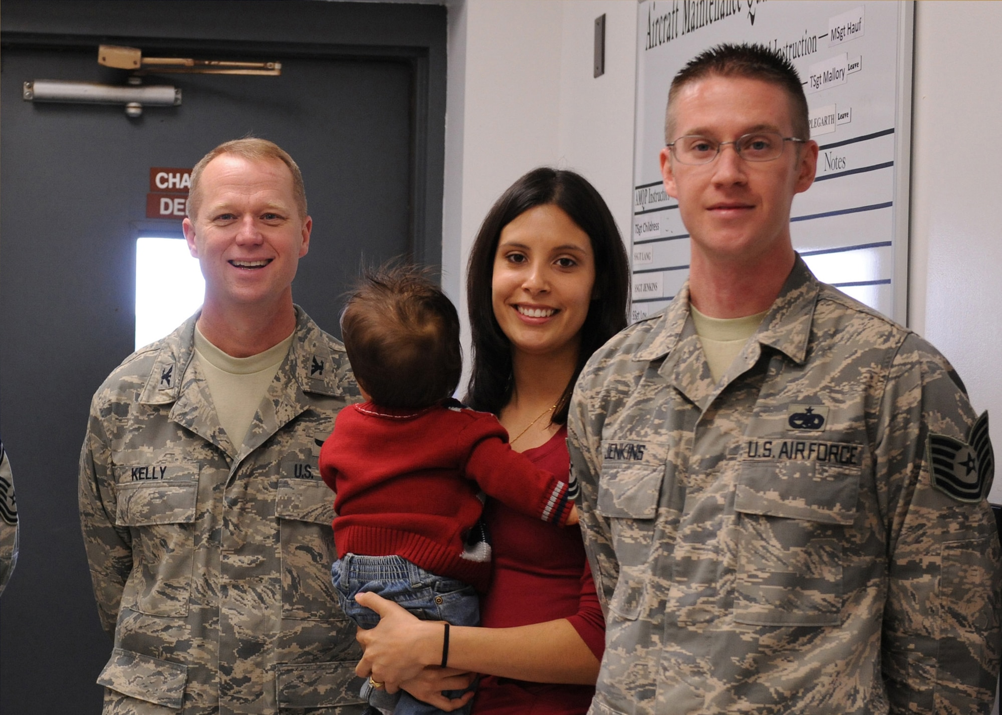 Technical Sgt. Travis Jenkins (far right), 4th Maintenance Operations Squadron,  and his wife and child are pictured with Colonel Mark D. Kelly (left), wing commander, after receiving a surprise promotion Dec. 24, 2008 at Seymour Johnson Air Force Base, N.C. The Stripes for Exceptional Performers Program rewards outstanding Airmen with promotions outside of the promotion cycle. (U.S. Air Force photo by Airman 1st Class Whitney Stanfield)