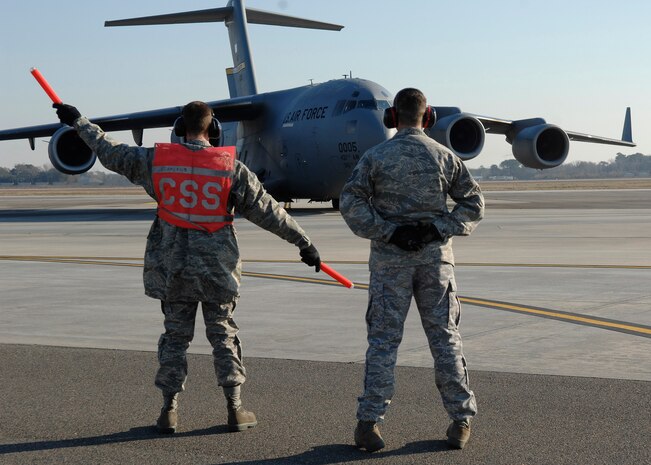 Tech. Sgt. Cameron Leslie watches as Airman Basic Benjamin Oehlke marshals a C-17 during training on the Charleston AFB flightline Jan. 21. For fiscal year 2008, five instructors from the training detachment taught a total of 5,678 hours, graduating 52 new C-17 crew chiefs. Sergeant Leslie is an instructor and Airman Oehlke is in training at the 373rd Training Squadron Detachment 5. (U.S. Air Force photo/Senior Airman Katie Gieratz)