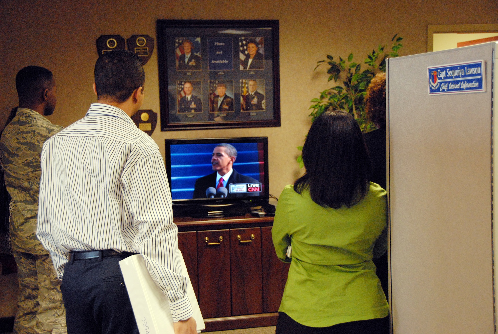 Base workers pause to watch the inauguration Tuesday. U. S. Air Force photo by Sue Sapp