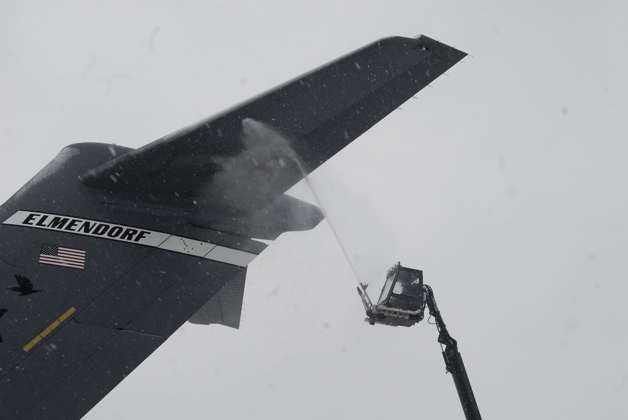 Staff Sgt. Gabe Stone, 43rd Aircraft Maintenance Squadron, attempts to de-ice a plane on Pope's Green Ramp Tuesday. As snow continued to fall throughout the day and the base was closed to non-mission essential personnel, the men and women of the 43rd AMXS continued their daily routines. This aircraft was bound for Elmendorf Air Force Base, Alaska, but it did not make it due to weather delays. (U.S. Air Force Photo by Tech. Sgt. Todd Wivell)