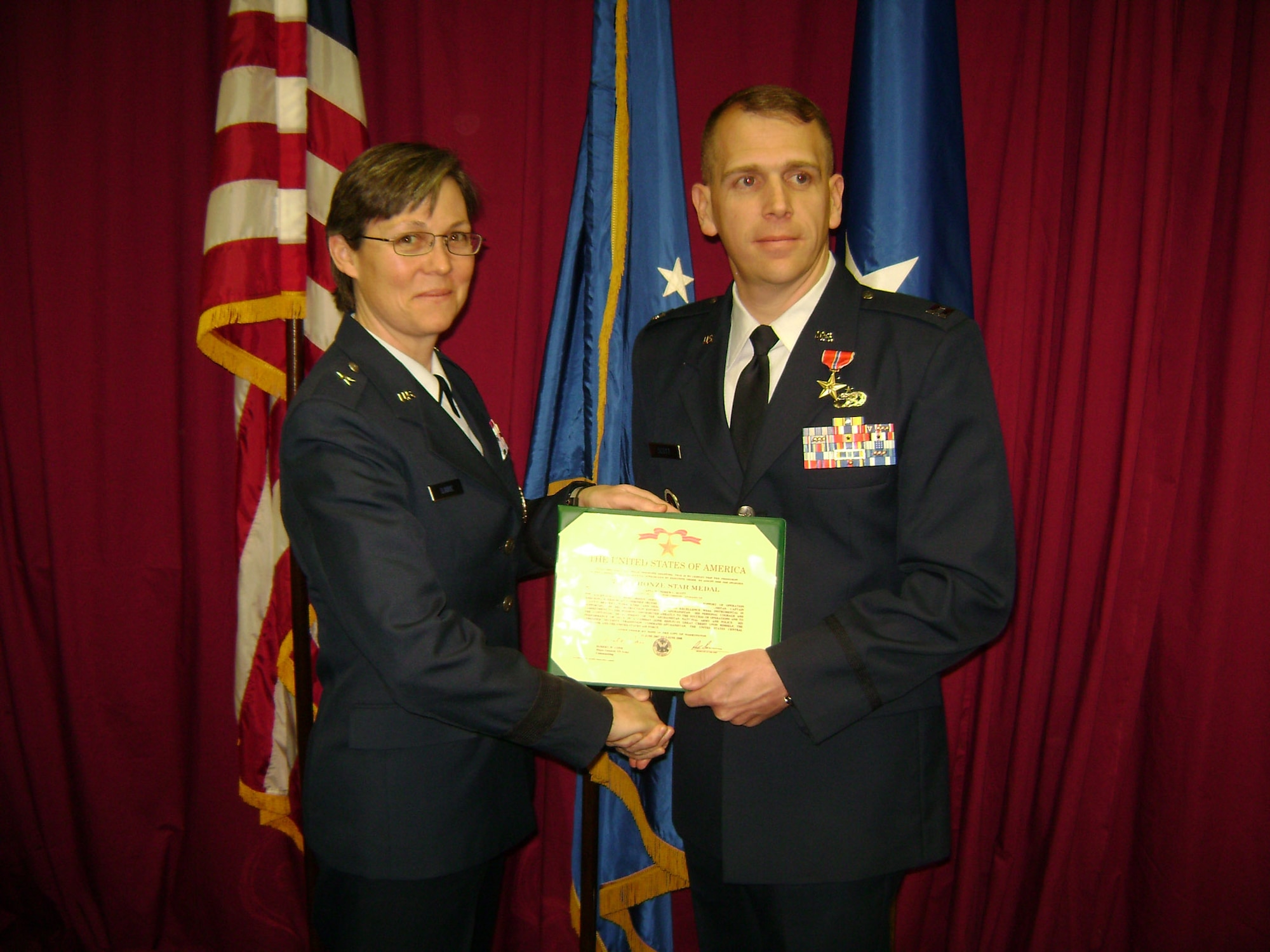 Capt. Andrew Scott (right), who is attached to the 78th Mission Support Squadron, receives a Bronze Star award citation from Brig. Gen. Teresa Djuric; Jeanne M. Holm Center Commander, Maxwell Air Force Base, Ala. U. S. Air Force photo by Maj. Douglas Lomsdalen 