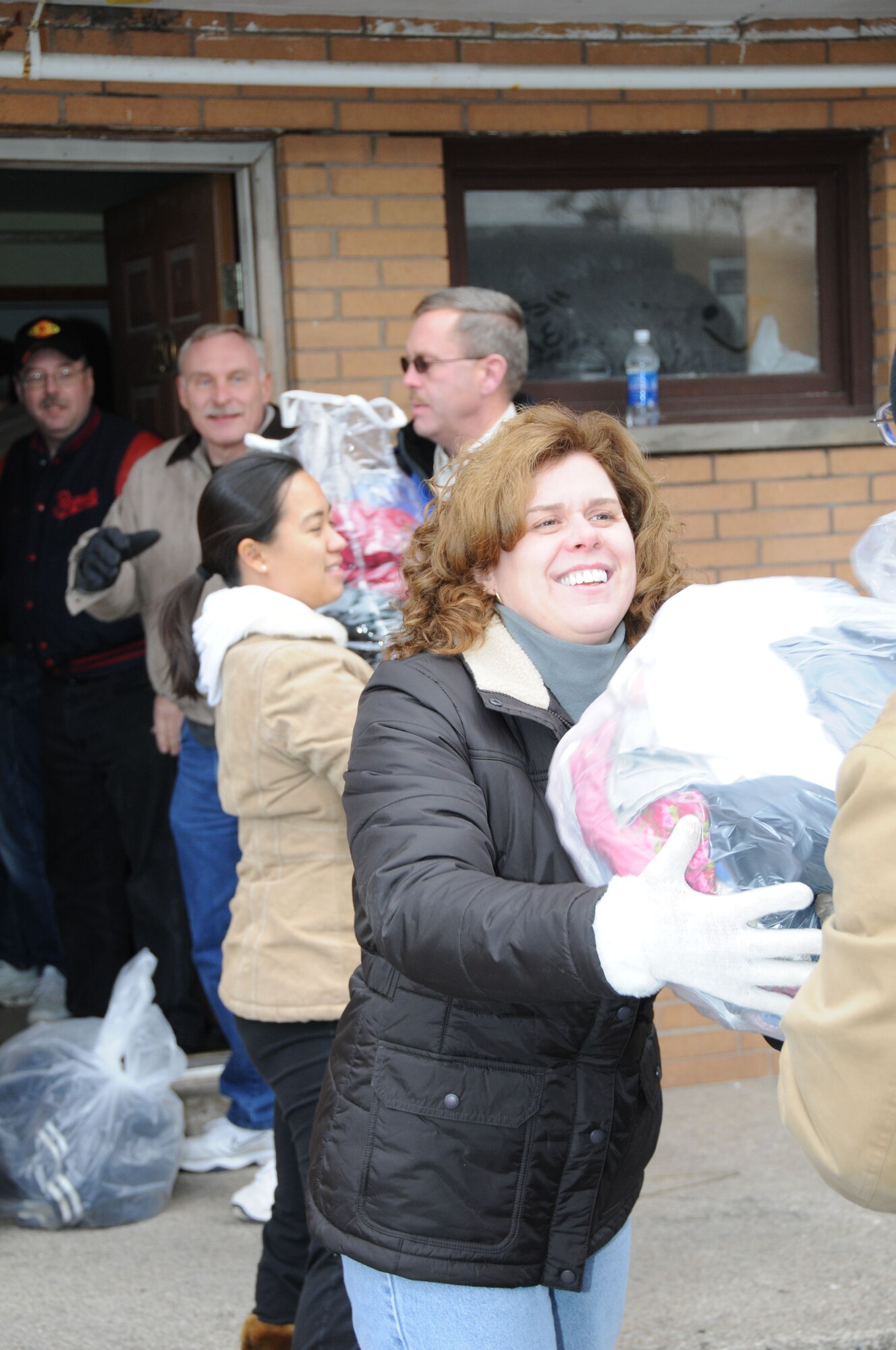 Jeannie Mang helps pass donated clothing down the line during a drop off to the Community Missions in Niagara Falls.
