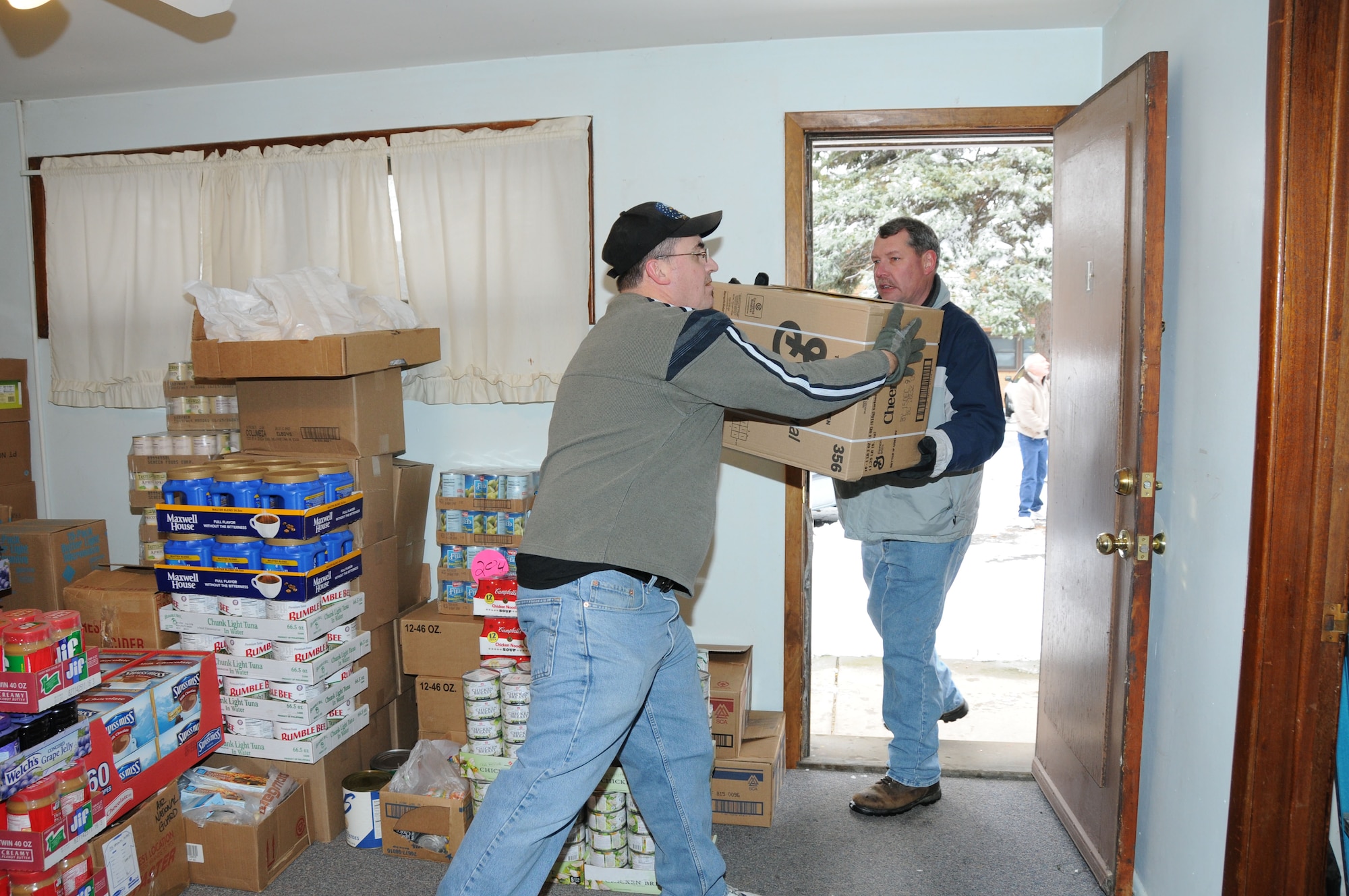 Roger Clark and Dale Selbert bring food donations into the Community Missions on December 16.