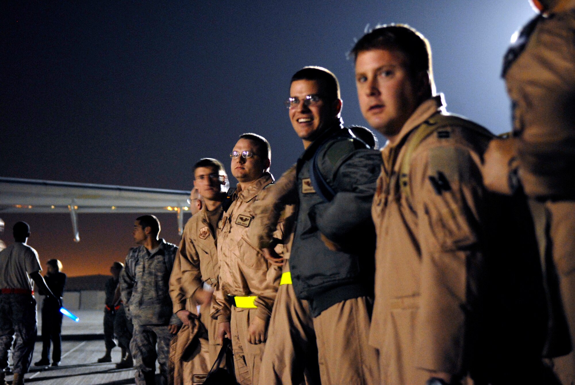 Airmen from Dyess Air Force Base, Texas, begin to form up as fellow Airmen continue to disembark from the aircraft that brought them to their deployment destination, Jan. 21, 2009, at an undisclosed location in Southwest Asia.  The personnel have arrived to relieve Airmen from Ellsworth Air Force Base, S.D., who have been flying and supporting B-1B bomber missions in support of Operation Iraqi and Enduring Freedom and Joint Task Force- Horn of Africa.  (U.S. Air Force Photo by Airman 1st Class Andrew Satran/Released)