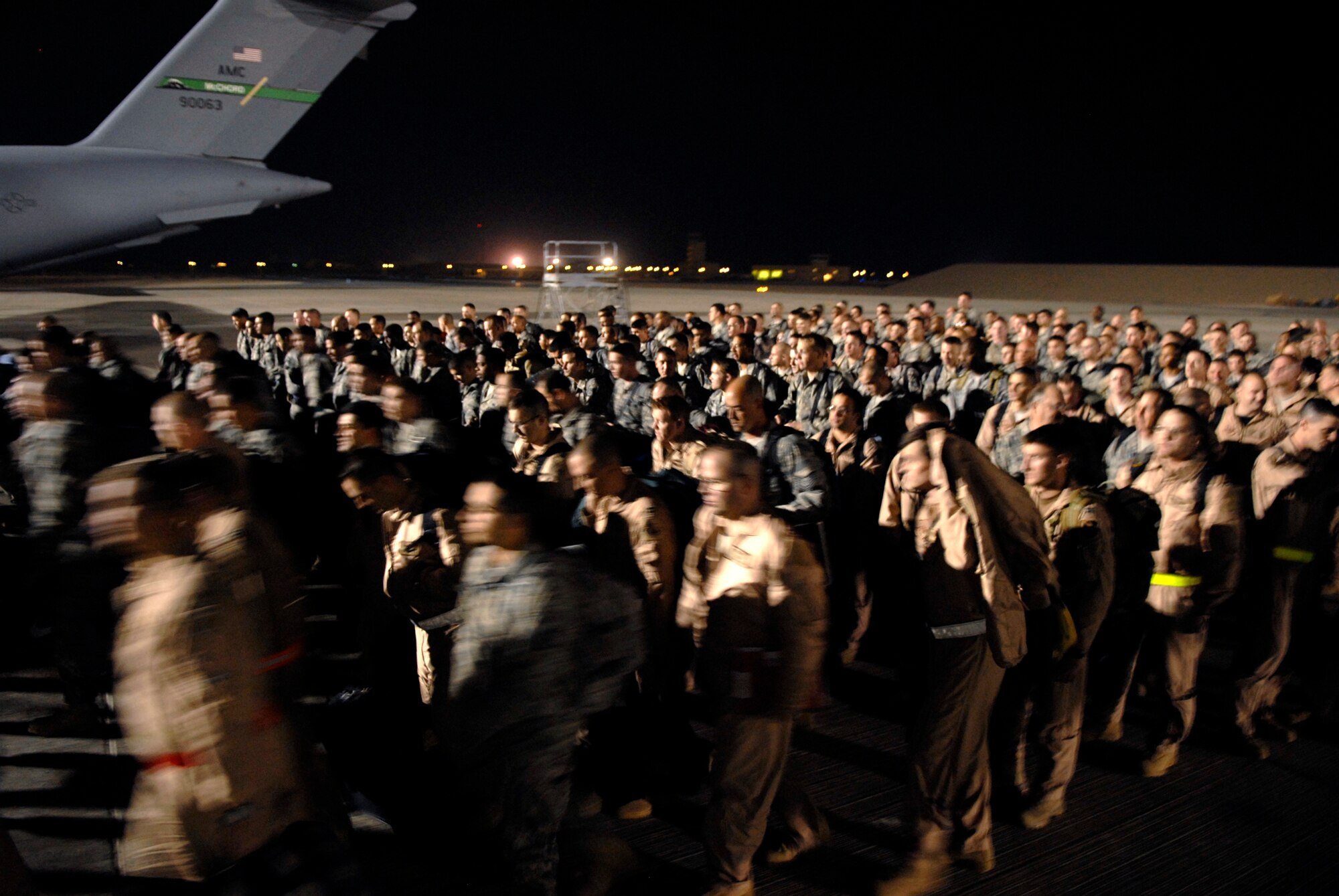 Airmen from Dyess Air Force Base, Texas, move out toward personnel processing after arriving at their deployment destination, Jan. 21, 2009, at an undisclosed location in Southwest Asia.  The personnel have arrived to relieve Airmen from Ellsworth Air Force Base, S.D., who have been flying and supporting B-1B bomber missions in support of Operation Iraqi and Enduring Freedom and Joint Task Force- Horn of Africa.  (U.S. Air Force Photo by Airman 1st Class Andrew Satran/Released)