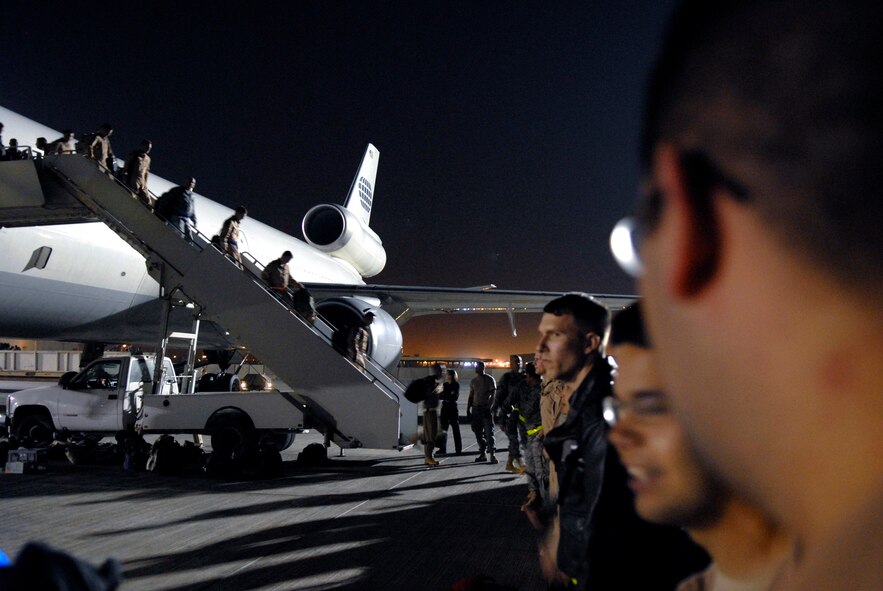 Airmen from Dyess Air Force Base, Texas, begin to form up as fellow Airmen continue to disembark from the aircraft that brought them to their deployment destination, Jan. 21, 2009, at an undisclosed location in Southwest Asia.  The personnel have arrived to relieve Airmen from Ellsworth Air Force Base, S.D., who have been flying and supporting B-1B bomber missions in support of Operation Iraqi and Enduring Freedom and Joint Task Force- Horn of Africa.  (U.S. Air Force Photo by Airman 1st Class Andrew Satran/Released)