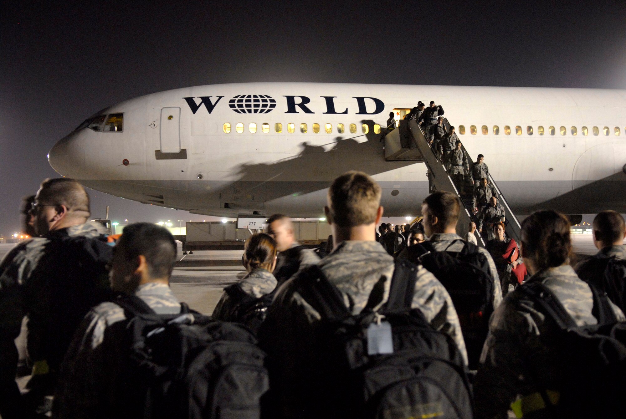 Airmen from Dyess Air Force Base, Texas, begin to form up as fellow Airmen continue to disembark from the aircraft that brought them to their deployment destination, Jan. 21, 2009, at an undisclosed location in Southwest Asia.  The personnel have arrived to relieve Airmen from Ellsworth Air Force Base, S.D., who have been flying and supporting B-1B bomber missions in support of Operation Iraqi and Enduring Freedom and Joint Task Force- Horn of Africa.  (U.S. Air Force Photo by Airman 1st Class Andrew Satran/Released)