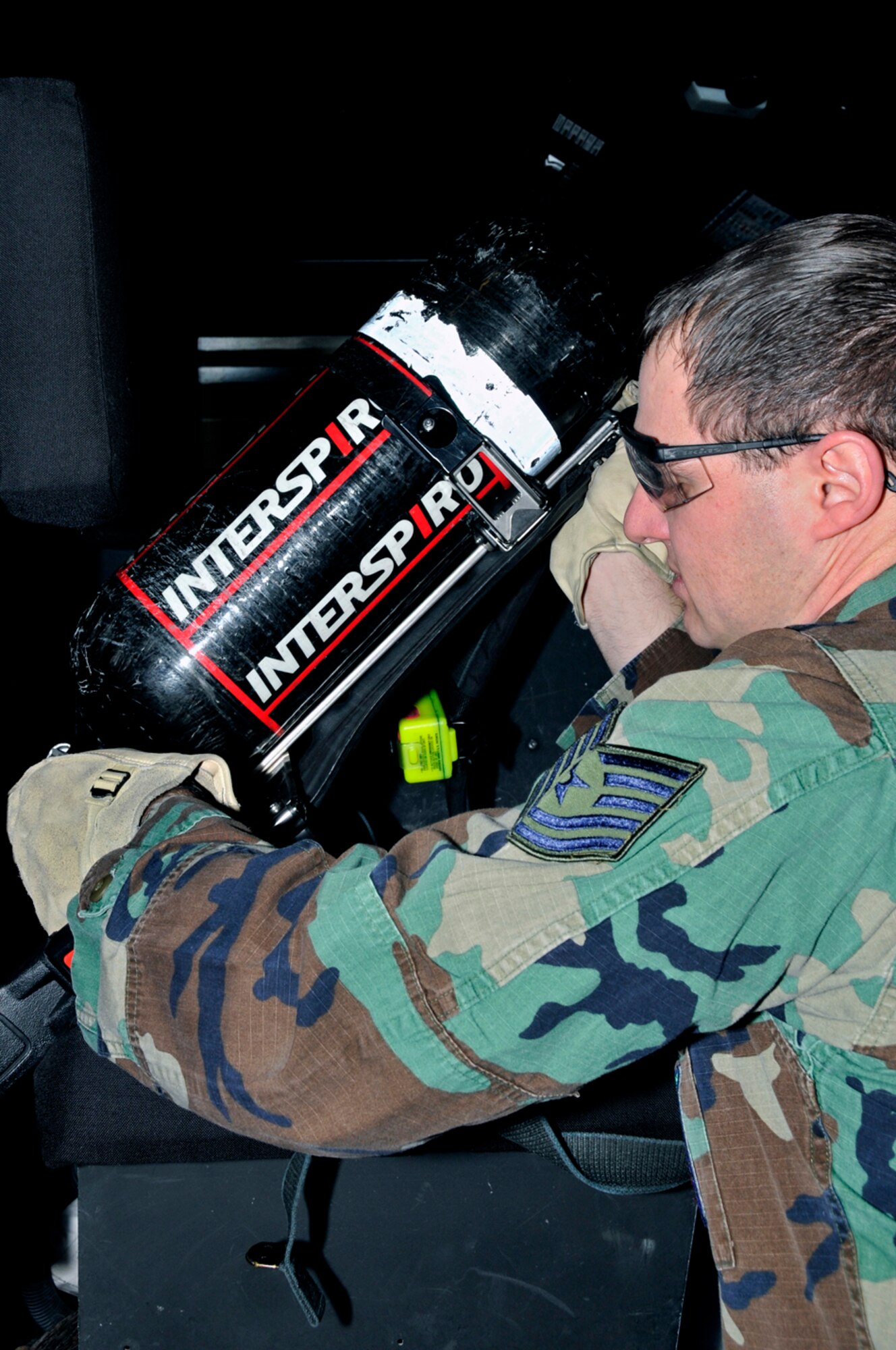 Tech. Sgt. Daniel Parker, 48th Civil Engineer Squadron firefighter, re-mounts his self contained breathing apparatus (SCBA) back into the fire engine Jan. 22 at RAF Lakenheath, England. An SCBA will provide the user with up to 30 minutes of fresh air. (U.S. Air Force photo by Airman 1st Class Perry Aston)