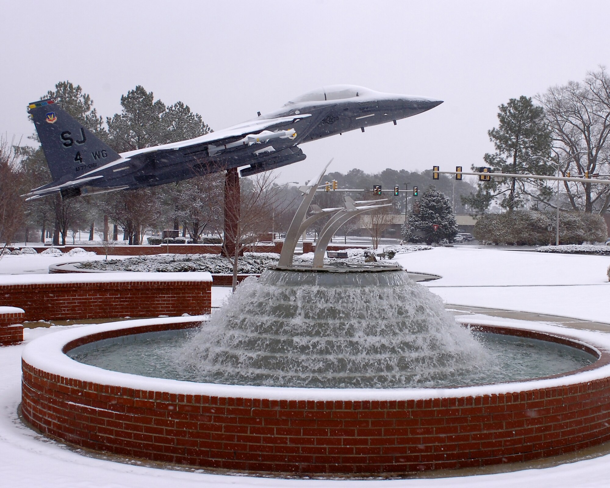 The F-15E Strike Eagle static display at the 4th Fighter Wing Headquarters building  sits blanketed in snow here at Seymour Johnson Air Force Base, N.C.  The unseasonable weather pattern dropped four to six inches of snow in a three hour period.  (U.S. Air Force photo by Master Sgt. Brandt Smith)    