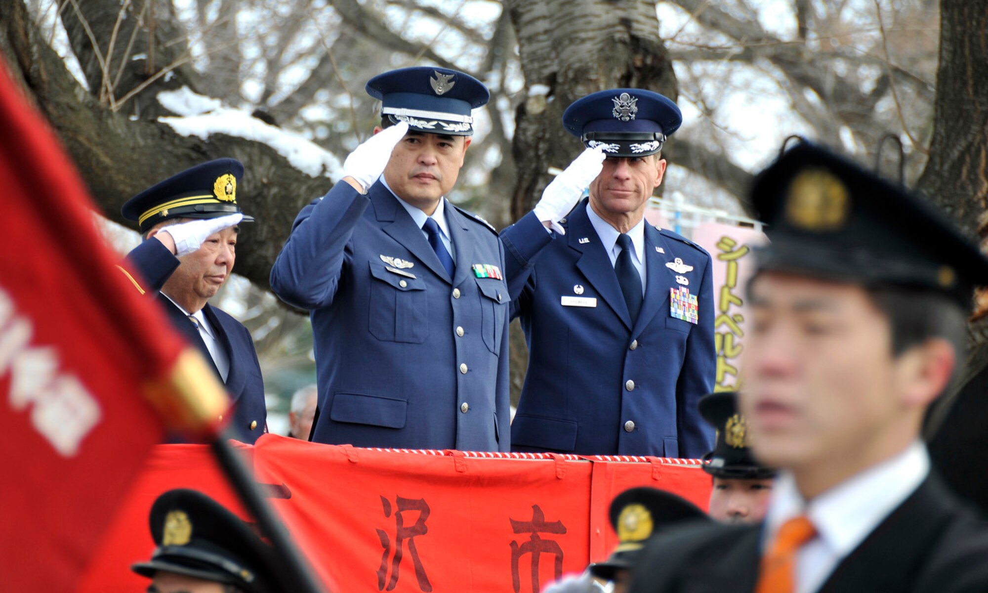 MISAWA CITY, Japan -- Kazumasa Taneichi, Misawa City Mayor, Col. Nobuhiro Shiota, Air Base Group 3rd Air Wing commander, and Col. David Stilwell, 35th Fighter Wing commander, salute several fire departments as they march by center stage during the Misawa City Fire Department New Year ceremony Jan. 18, 2009. The ceremony took place on the streets of Misawa and in the Misawa Civic Centerl. (U.S. Air Force photo by Senior Airman Chad Strohmeyer)