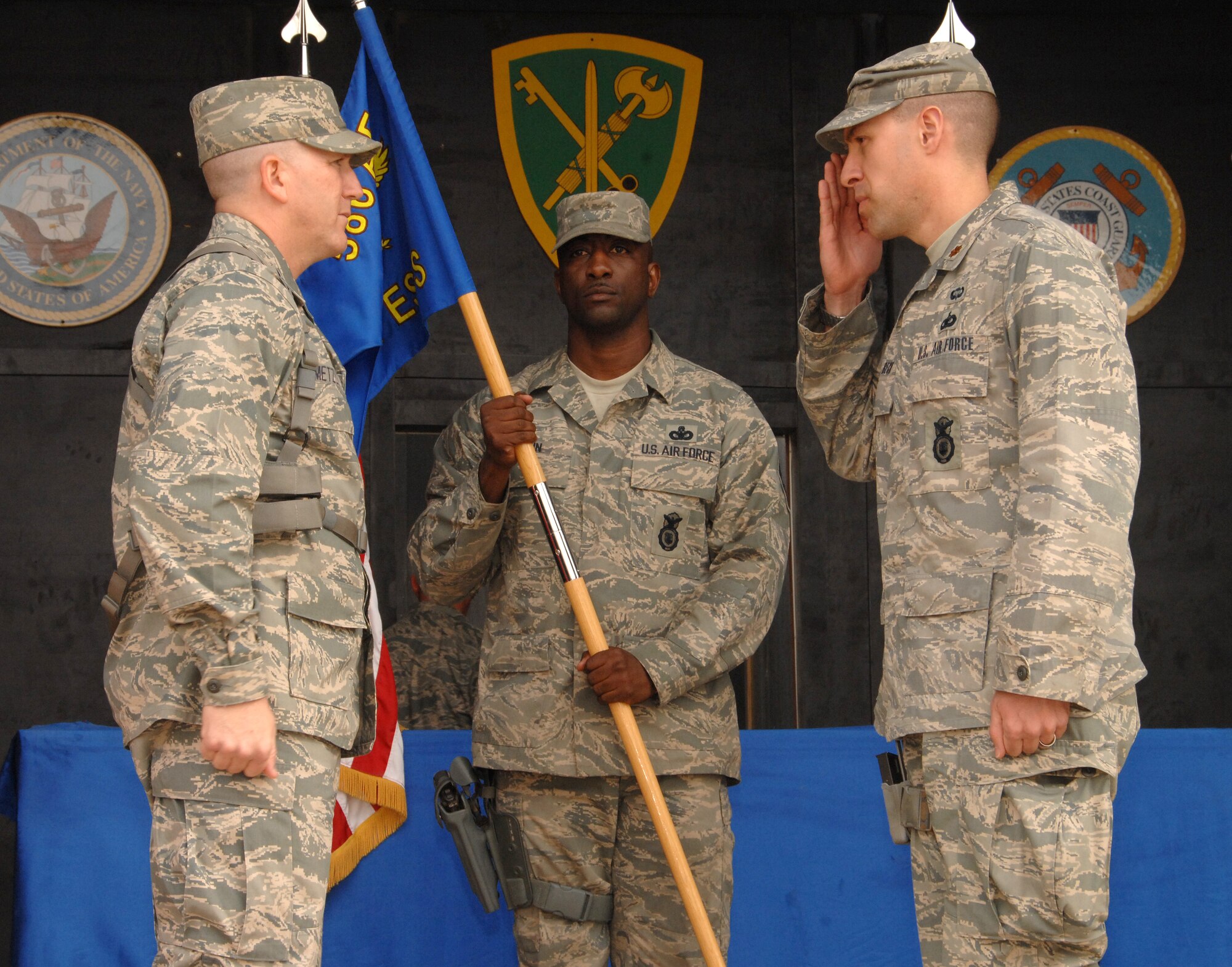 Major Jason Beck receives command of the 887th Expeditionary Security Forces Squadron from Colonel Alan Metzler, 586th Air Expeditionary Group Commander, Jan. 20 at Camp Bucca, Iraq. The 586th AEG provides security and transportation for visitors who are allowed to visit daily with detainees being held at the Theater Internment Facility. (U.S. Air Force photo/Senior Airman Courtney Richardson)