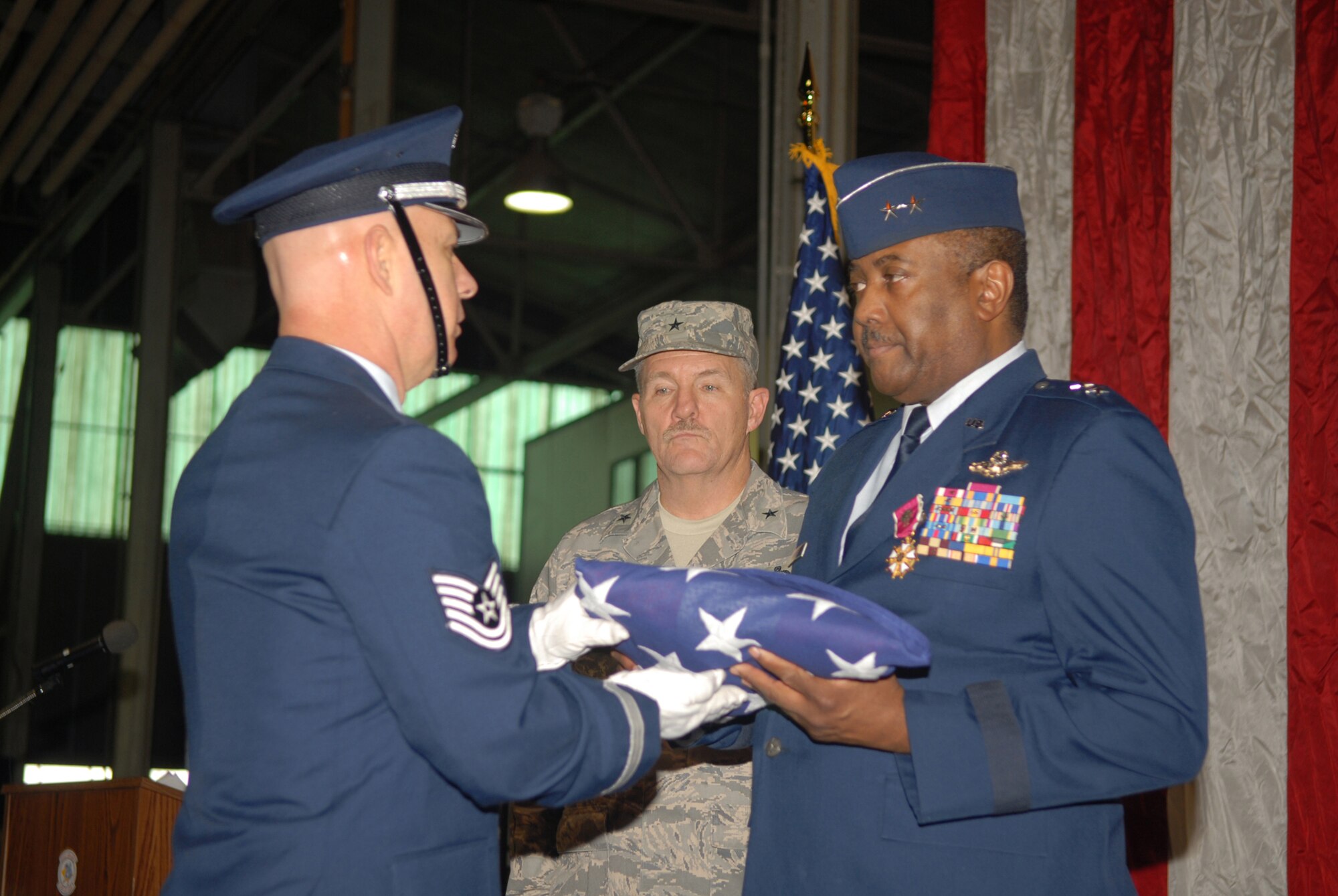 Brig. Gen. Hugh Broomall (middle, rear) Deputy Adjutant General for Air, Delaware National Guard, watches as 166th Airlift Wing Honor Guard member Tech. Sgt. Bill Austin presents Brig. Gen. Ernest Talbert, vice-commander, Delaware Air National Guard, his personal American flag during Gen. Talbert's retirement ceremony in New Castle, Del. on Jan. 11, 2009. Gen. Talbert had just received the honorary rank of major general in the Delaware National Guard. Gen. Talbert, a rated command pilot with more than 6,500 flight hours, flew C-130 aircraft missions in Operation Desert Storm and was the 166th Airlift Wing commander in Operation Iraqi Freedom. During his 36-year career he became the first African-American colonel in the Delaware ANG and the first and only African-American general in the over 350-year history of the Delaware National Guard. (U.S. Air Force photo/Staff Sgt. Melissa Chatham)