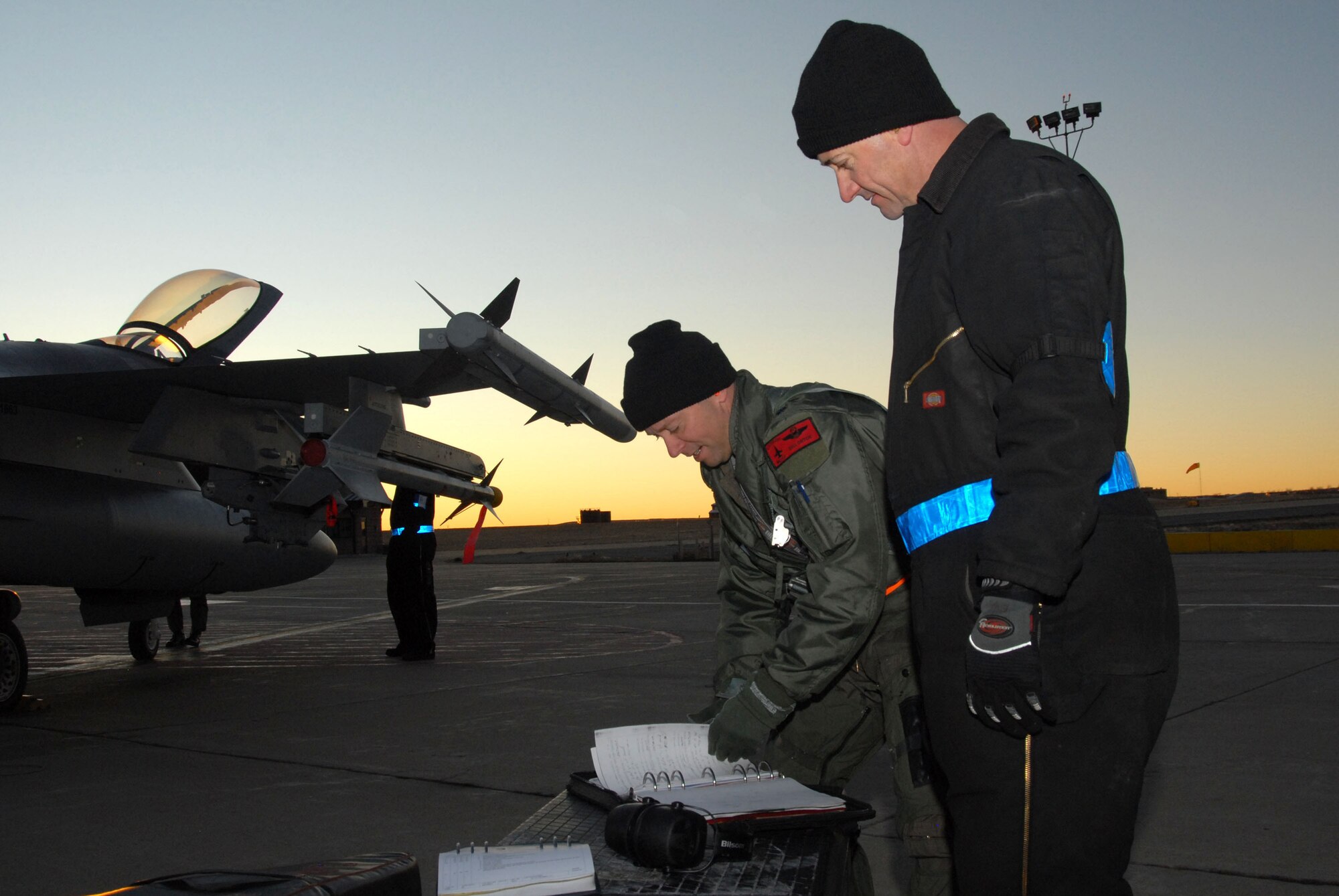 William E. Orton "Willy-O", a pilot from the 120th Operations Flight, performs pre-flight checks on his F-16 aircraft during an Operational Readiness Inspection, as the Crew Chief looks on.