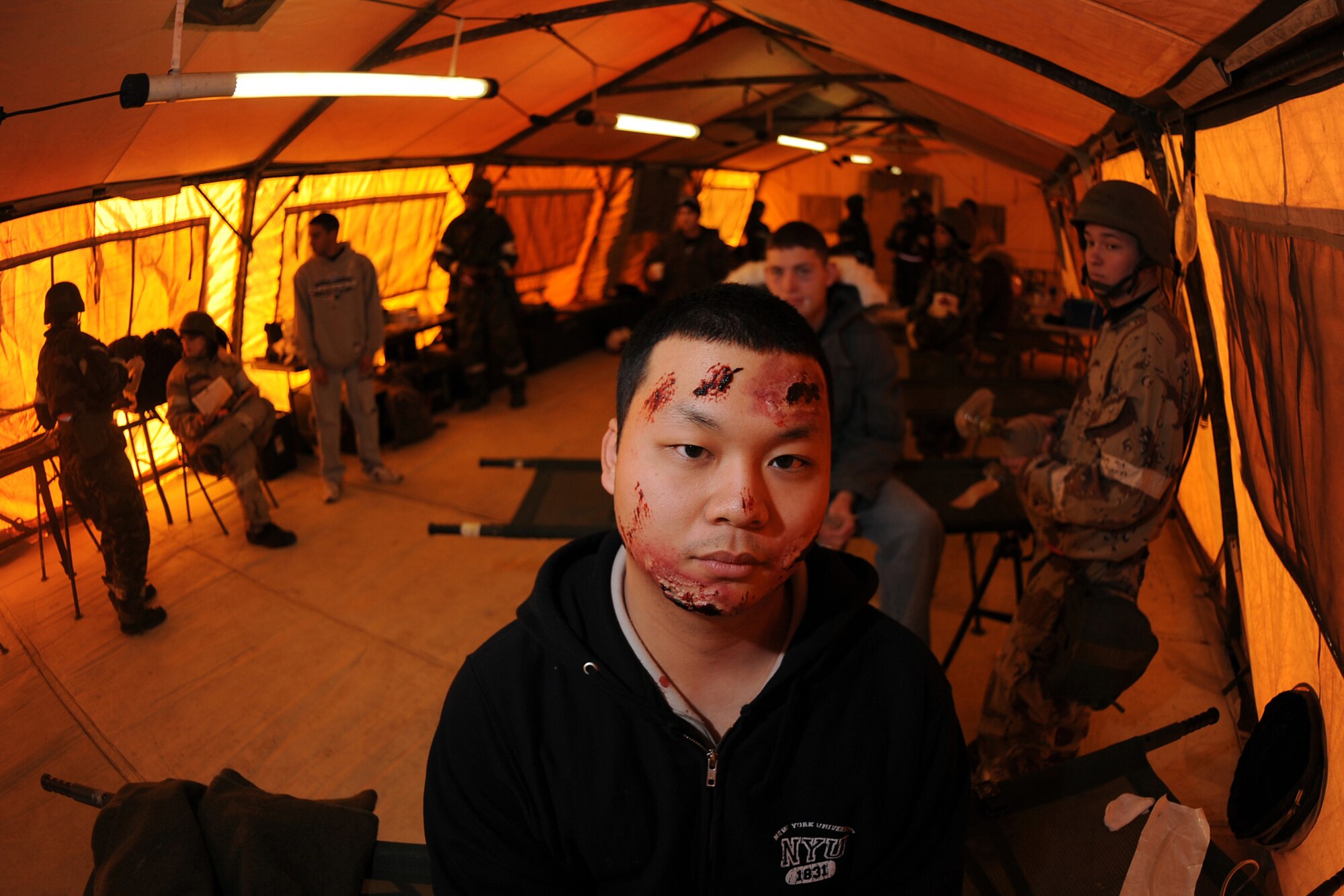 OFFUTT AIR FORCE BASE, Neb. --  Senior Airman Alvar Lam, 338th Combat Training Squadron, shows off mock facial wounds inside the medical tent as part of an Operational Readiness Exercise Jan. 22. Airman Lam and other 55th Wing Airmen went through a thorough three day exercise to test their mission skills prior to deploying. The 55th Wing is in preparation for an Operational Readiness Inspection Sept. 10-16.

U.S. Air Force Photo by Josh Plueger