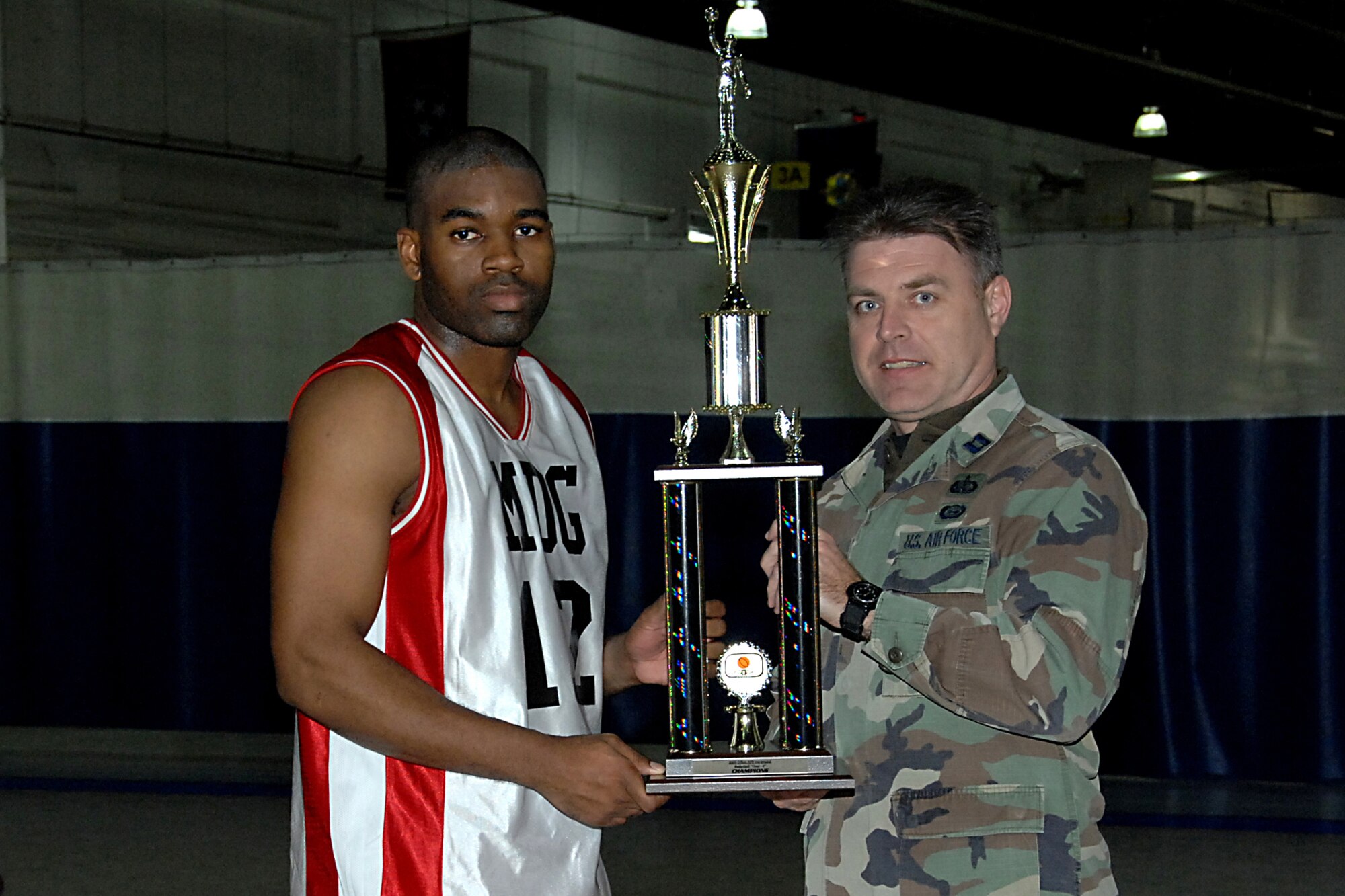 Senior Airman Kevin Morrow posing with the 2009 Championship trophy along with Captain Anderson, Combat Support Flight Chief, Force Support Squadron.
