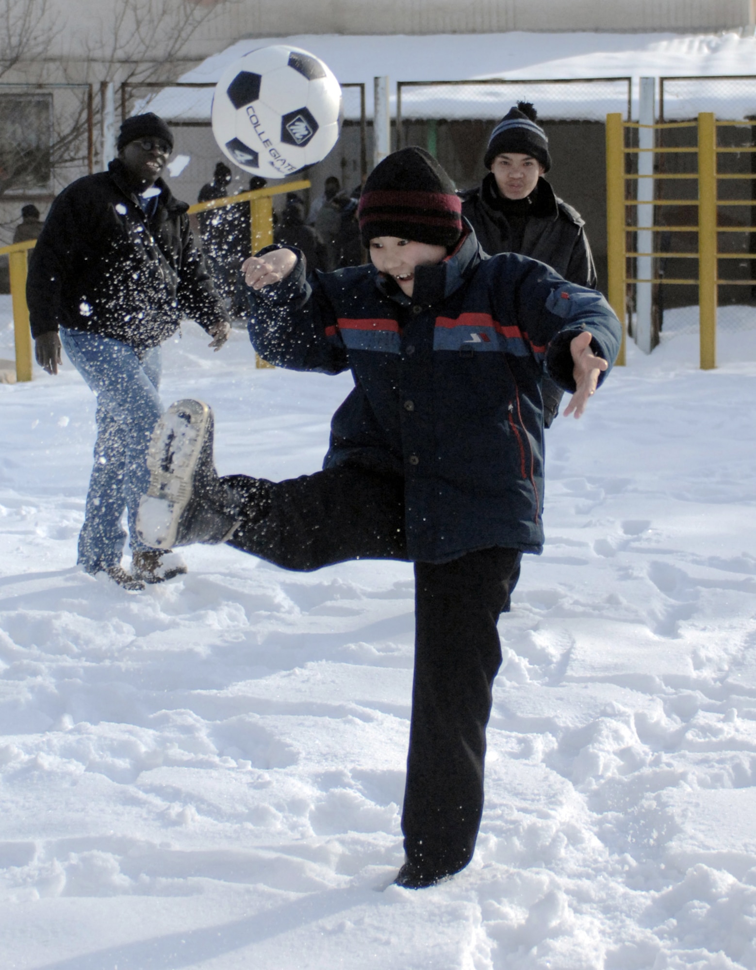 A young boy shows off his soccer skills to Staff Sgt. Milbert Bourgeois Jan. 11 at the Belovodosky orphanage north of Bishkek, Kyrgyzstan. Airmen from nearby Manas Air Base visit the orphanage frequently to share friendship and donate toys as well as clothing, blankets, diapers and toiletries. Sergeant Bourgeois is a Nevada Air National Guardsman deployed to the 376th Expeditionary Security Forces Squadron here. (U.S. Air Force photo/Tech. Sgt. Phyllis Hanson) 

