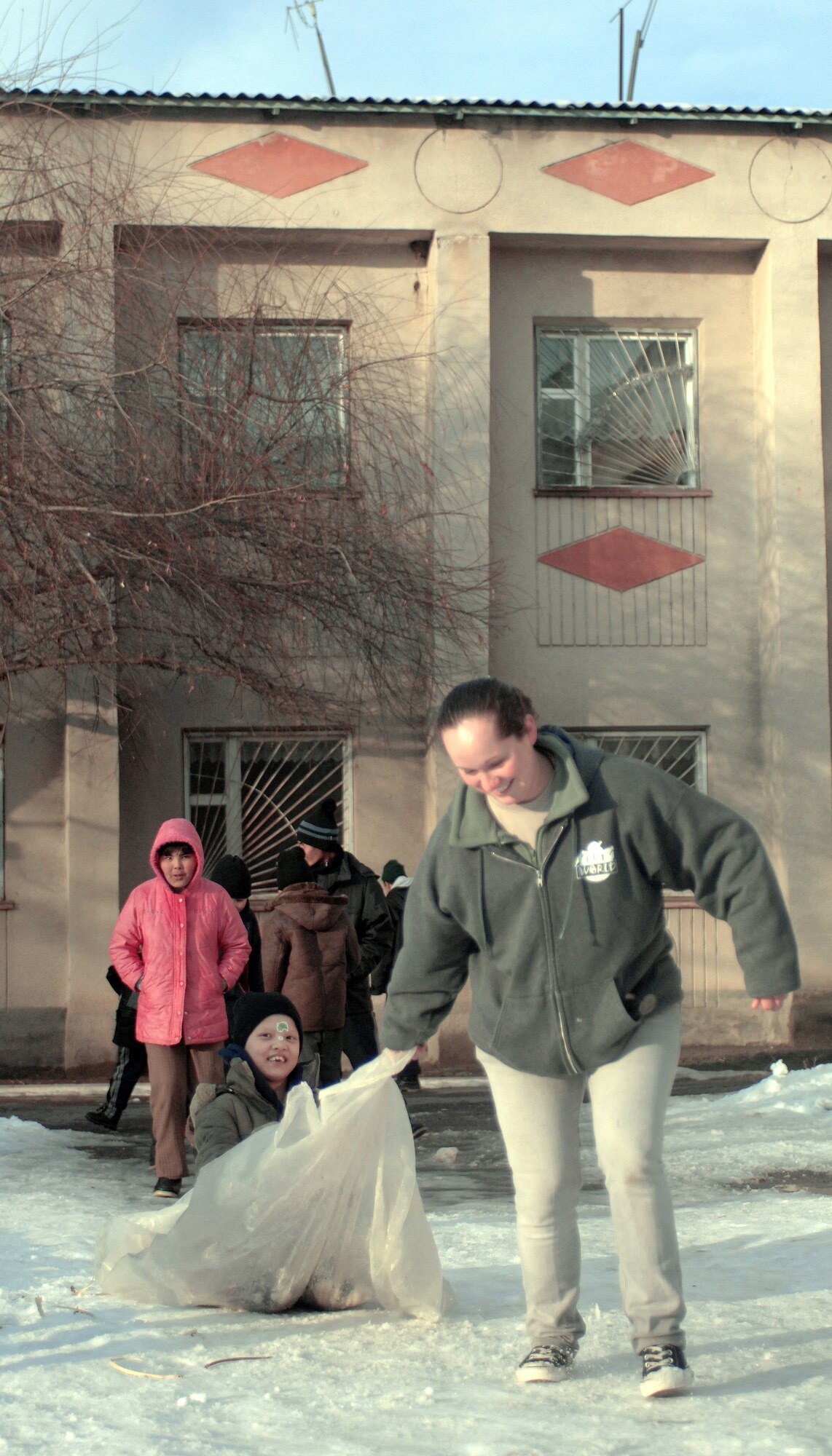 Airman 1st Class Jennifer Morrell gives a boy a ride on a makeshift sled Jan. 11 at the Belovodosky orphanage north of Bishkek, Kyrgyzstan. Airmen from nearby Manas Air Base visit the orphanage frequently to share friendship and donate toys as well as clothing, blankets, diapers and toiletries. Airman Morrell is deployed with the 376th Expeditionary Aircraft Maintenance Squadron. (U.S. Air Force photo/Tech. Sgt. Phyllis Hanson) 
