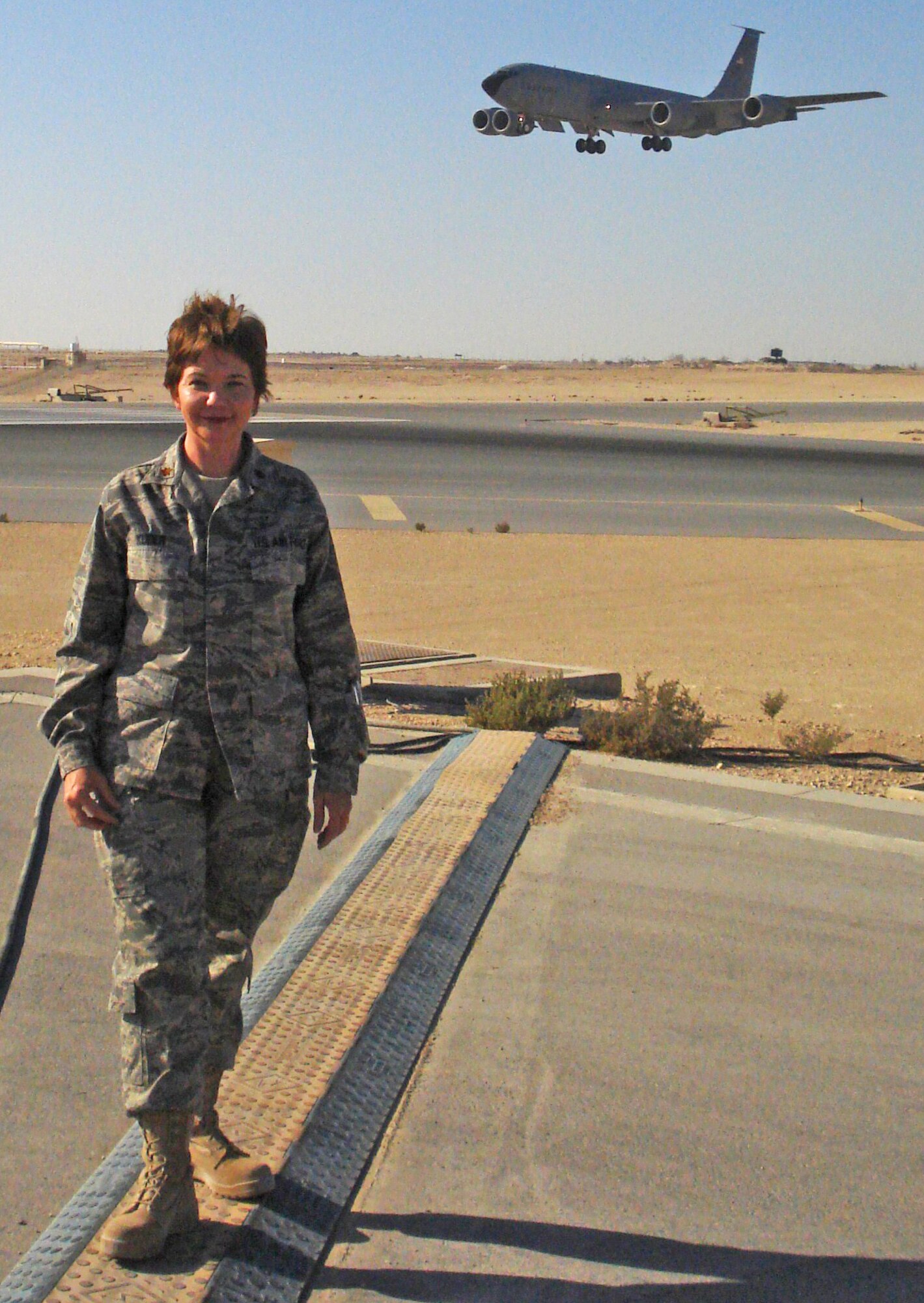A KC-135 Stratotanker flies by Maj. Martha Kuder at her deployed location in Southwest Asia. Major Kuder is a performance manager assigned to the 931st Air Refueling Group, an Air Force Reserve unit at McConnell Air Force Base, Kan. She volunteered for active-duty orders in support of the Global War on Terrorism as an executive officer for the 379th Expeditionary Operations Group. The world's largest KC-135 squadron in combat is assigned to the 379th EOG. (Courtesy photo)                          