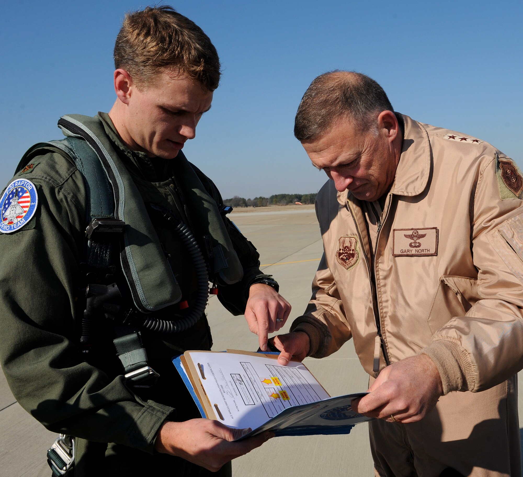 LANGLEY AIR FORCE BASE, Va. -- Maj. Dave “Zeke” Skalicky, F-22 Raptor demonstration pilot, reviews certification papers with Lt. Gen. Gary North, 9th Air Force commander, here Jan. 21. Major Skalicky performed this year’s demonstration for certification by General North and Brig. Gen. Mark Barrett, 1st Fighter Wing commander.  The certification demonstration for Gen. John D.W. Corley, commander of Air Combat Command, is scheduled for Feb. 4. (U.S. Air Force photo/Airman Rebecca Montez)