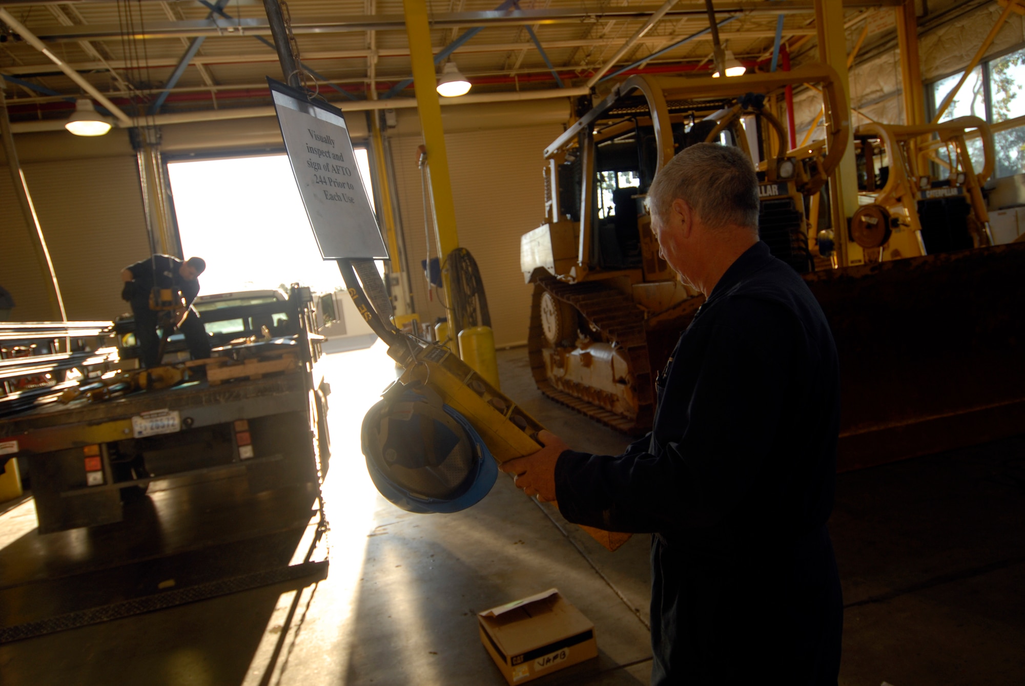VANDENBERG AIR FORCE BASE, Calif. --  Ken Helling, foreground, and Staff Sgt. Dennis Berry, vehicle mechanics with the 30th Logistics Readiness Squadron, operate an over-head crane to place hydraulic cylinders onto a flatbed truck Jan. 13. (U.S. Air Force photo/Senior Airman Christian Thomas)