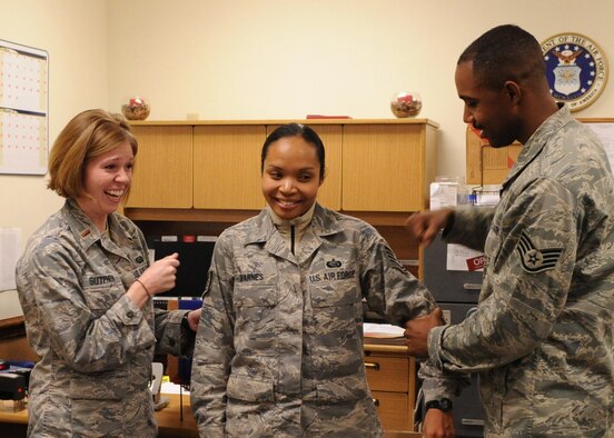 Technical Sgt. Lillian Barnes, 4th Force Support Squadron, has her new stripes pinned on by her husband, Staff Sgt. Richard Barnes III and 2nd Lieutenant Kelli Sutphen after a surprise promotion Dec. 24, 2008 here at Seymour Johnson Air Force Base, N.C. The Stripes for Extraordinary Performers programs rewards outstanding Airmen with promotions outside of their promotion cycle. (U.S. Air Force photo by Airman 1st Class Whitney Stanfield)
