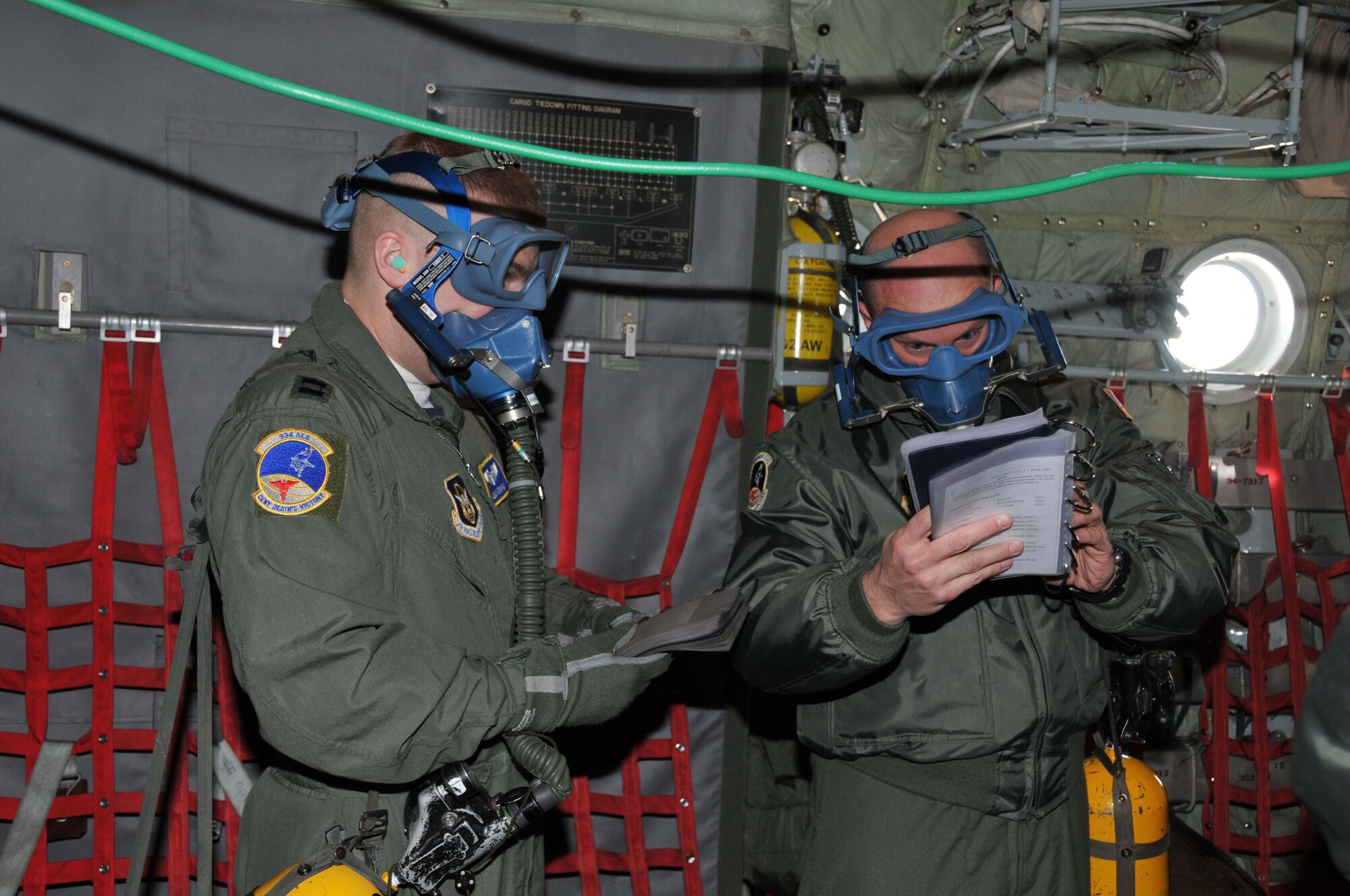 Capt. Adam Hohman (left) and Senior Airman Chris Varone, 934th Aeromedical Evacuation Squadron, don oxygen masks as they train for in flight emergencies en route to MacDill AFB, Fla.  The AES members combined with crews from Peterson AFB, Colo. combining their assets to make training more efficient.  To read the full story of the deployment go to www.minneapolis.afrc.af.mil. (Air Force Photo/Master Sgt. Darrell Habisch)