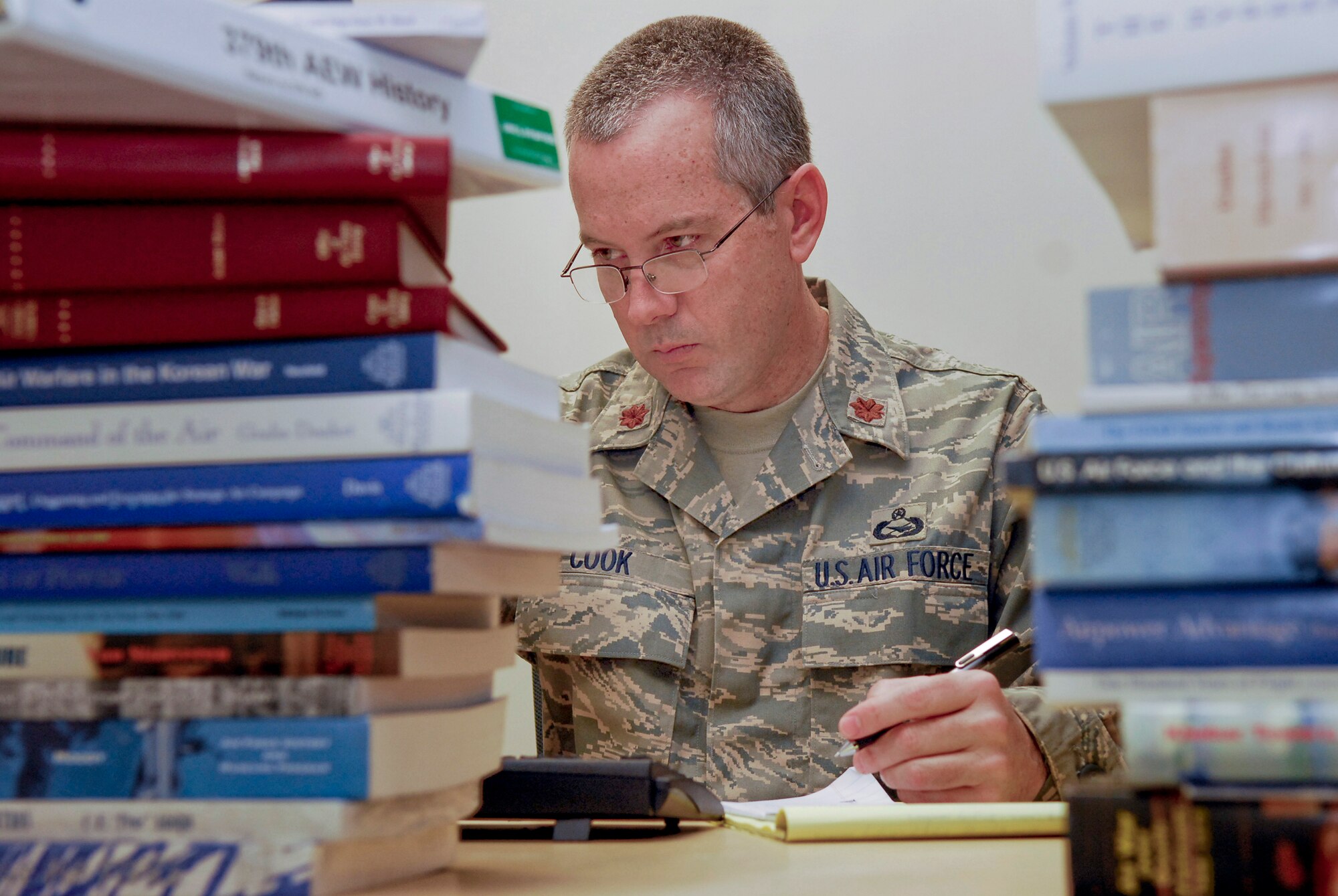 Major Brian Cook, the 379th Air Expeditionary Wing Historian, has a collection of reference material to aid his ongoing task of collecting, cataloging, and retrieving historical information which documents the more than 65 year legacy of the Grand Slam Wing, Jan. 23, 2009, in an undisclosed location in Southwest Asia.  Maj. Cook hails from Monument, Colo. and is deployed from Peterson Air Force Base, Colo. in support of Operation Iraqi and Enduring Freedom and Joint Task Force- Horn of Africa.  (U.S. Air Force Photo by Airman 1st Class Andrew Satran/Released)