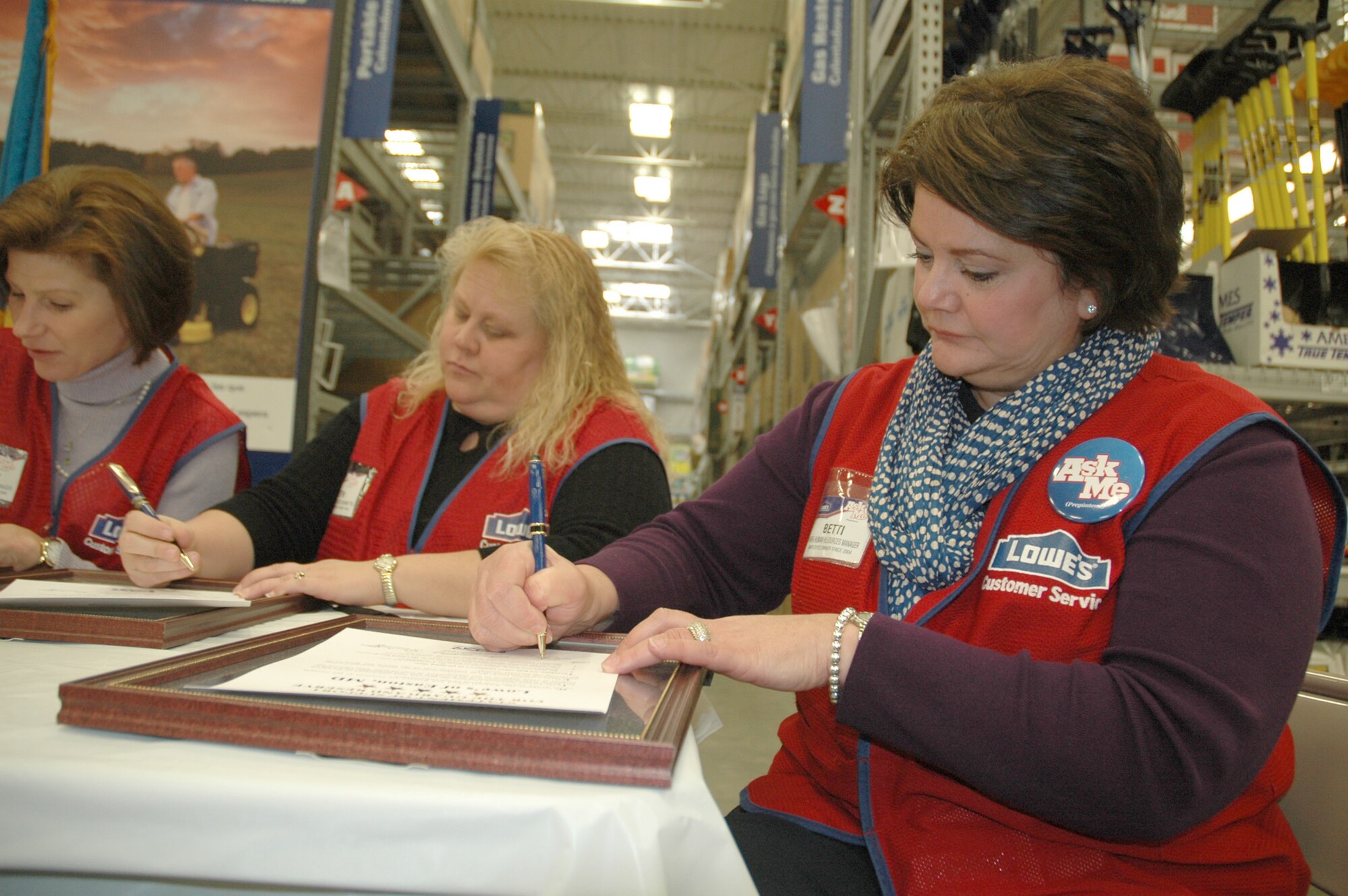 DOVER AIR FORCE BASE, Del. -- Bette Sharp, a Lowe's Area Human Resources Manager, signs a contract written up by the Employer Support of the Guard and Reserve showing their backing of Lowe's employees who are also military members Jan. 22. The event was held at the Lowe's store in Middletown, Del., and had military members representing the Army, Navy, Air Force and Marines. 512th Airlift Wing Commander Col. Randal L. Bright attended the event. He is the commander of the only Air Force Reserve unit in Delaware. (U.S. Air Force photo/ Senior Airman Andria J. Allmond).  