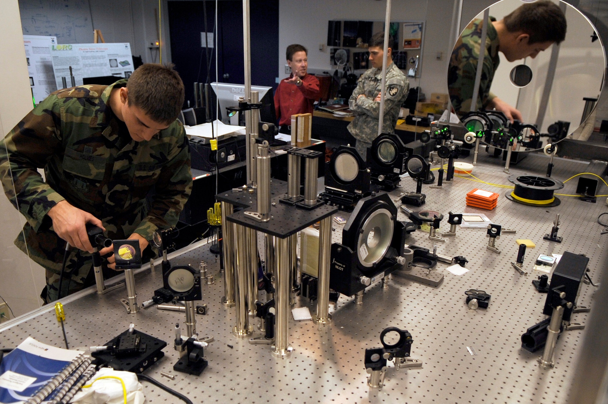 U.S. Air Force Academy Cadet Will Holmes conducts holographic adaptics optics research with U.S. Military Academy Cadet Richard Carter and Dr. Geoff Andersen Jan. 22 at the Academy in Colorado. Dr. Andersen is a research associate, teaches cadets and conducts experiments at the Laser and Optics Research Center. Cadet Carter is a junior in a exchange unit from West Point and Cadet Holmes is a senior at the Academy. (U.S. Air Force photo/Staff Sgt. Desiree N. Palacios) 
