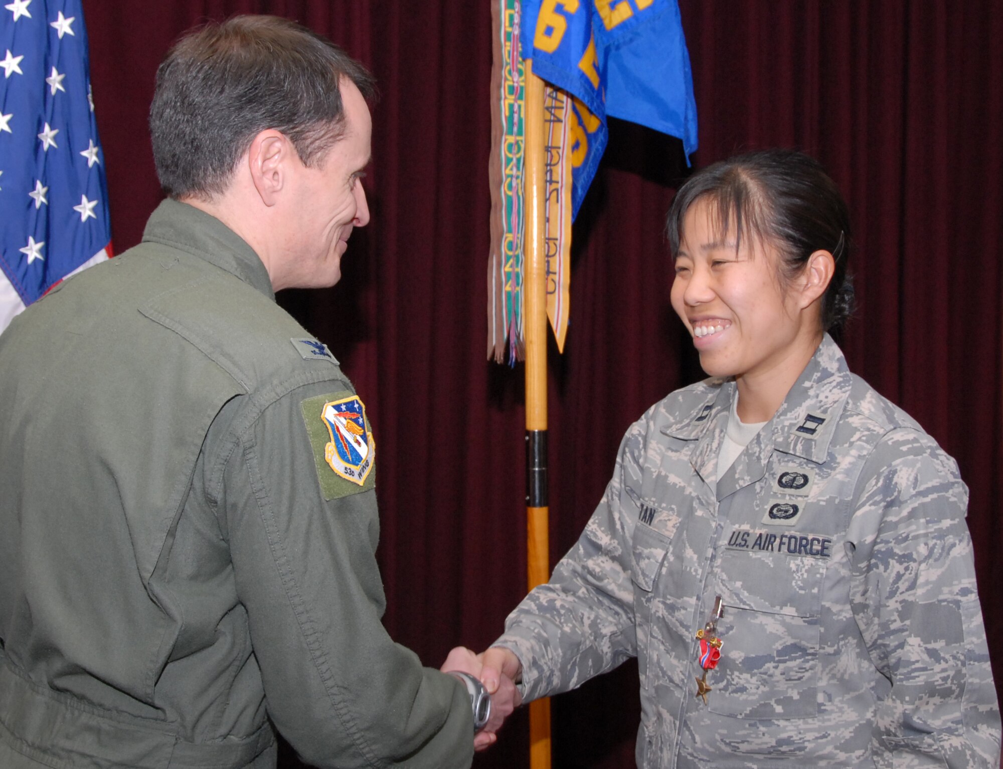 Capt. Pamela Tan, 36th Electronic Warfare Squadron, thanks Col. Steve DePalmer, 53d Wing commander,  after receiving her Bronze Star medal Jan. 22 during a 36 EWS commander's call.  She received the medal for her accomplishments as a Electronic Warfare Officer deployed with a Army battalion in Iraq.  (U.S. Air Force photo/Samuel King Jr.)