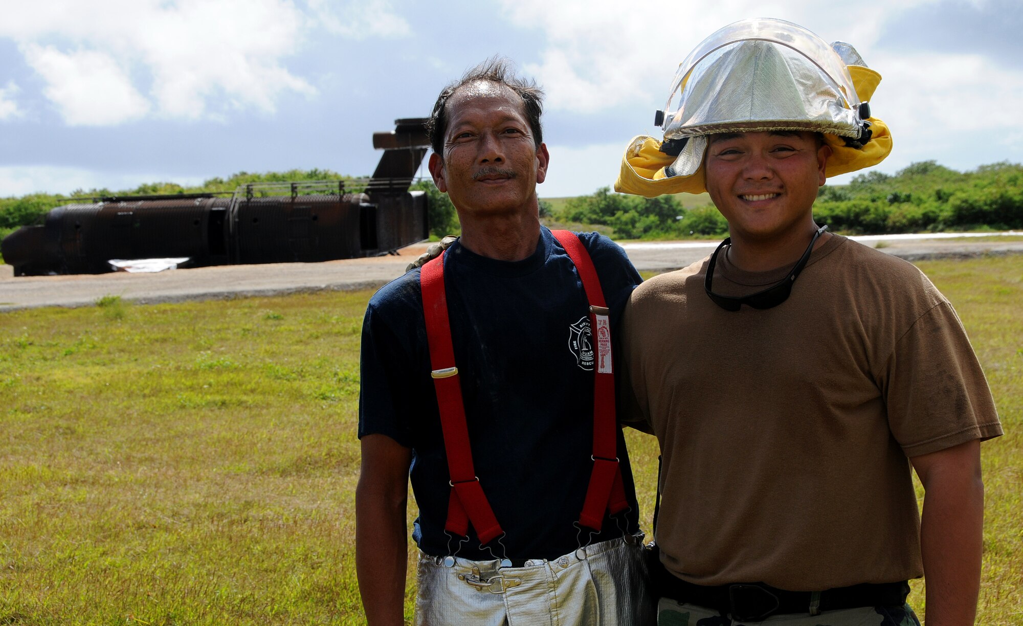 ANDERSEN AIR FORCE BASE, Guam - Father-son duo John R. Ballesta from the Won Pat International Airport Fire Department and John Robert Ballesta from Andersen's Fire and Emergency Services Flight train together during a joint training mission with fire departments from the Department of Defense, Government of Guam and the international airport here Jan. 22. John R. Ballesta, the father, has been a firefighter for more than 20 years. He first joined in 1988 with the Navy Federal Fire Department. After the Navy Federal Fire Department closed 28 men, including himself, transferred to the Won Pat Fire Department. His son Staff Sgt. John Robert Ballesta is stationed here. (U.S. Air Force photo by Airman 1st Class Courtney Witt)