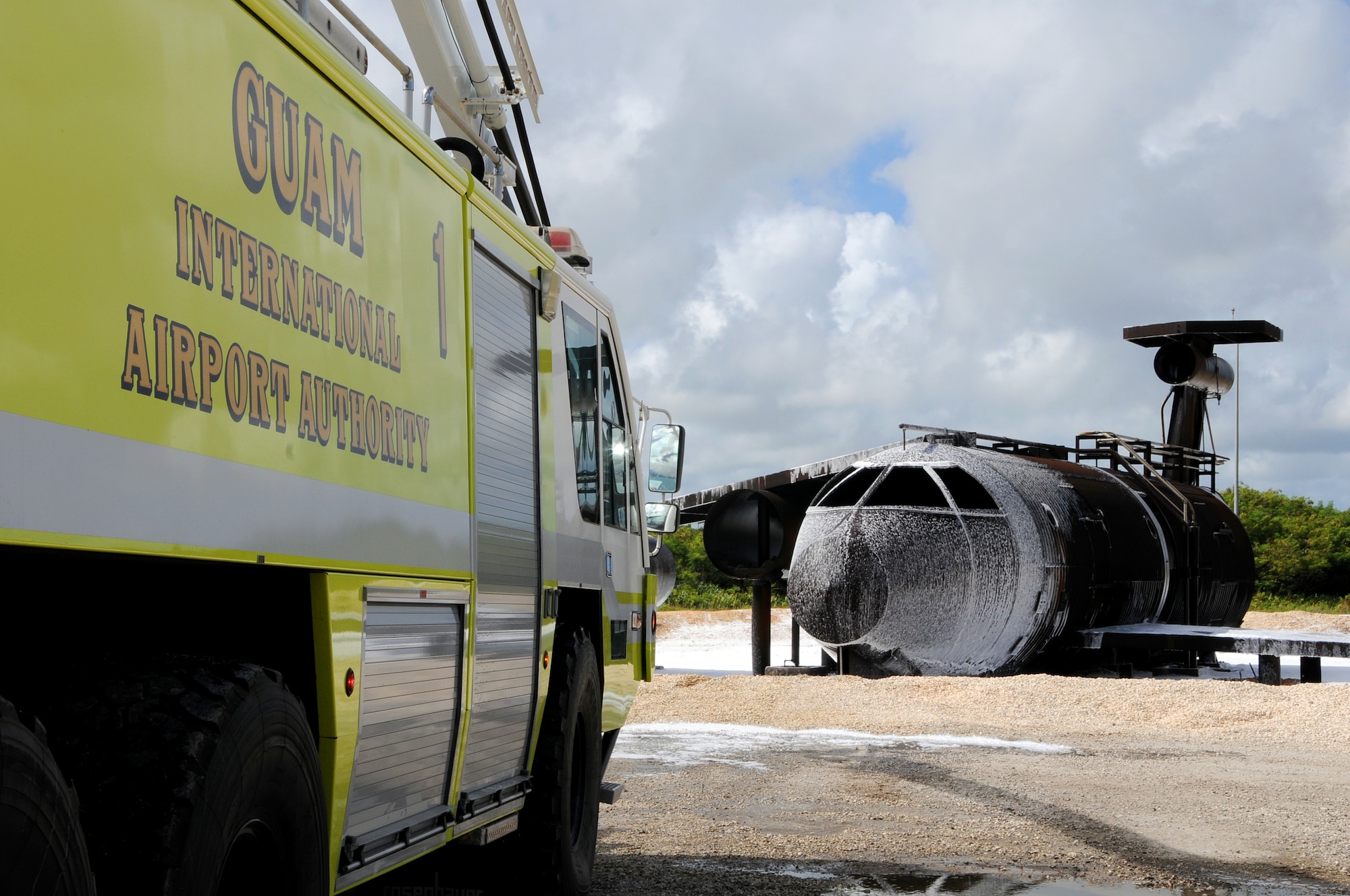 ANDERSEN AIR FORCE BASE, Guam – Firefighters in a Won Pat International Airport fire truck successfully extinguish a fire on the aircraft fire trainer during joint training with Department of Defense, Government of Guam, and airport fire departments here Jan. 22. The aircraft fire trainer allows firefighters to train for a variety of scenarios they may experience from exterior fires to interior emergencies. (U.S. Air Force photo by Airman 1st Class Courtney Witt)