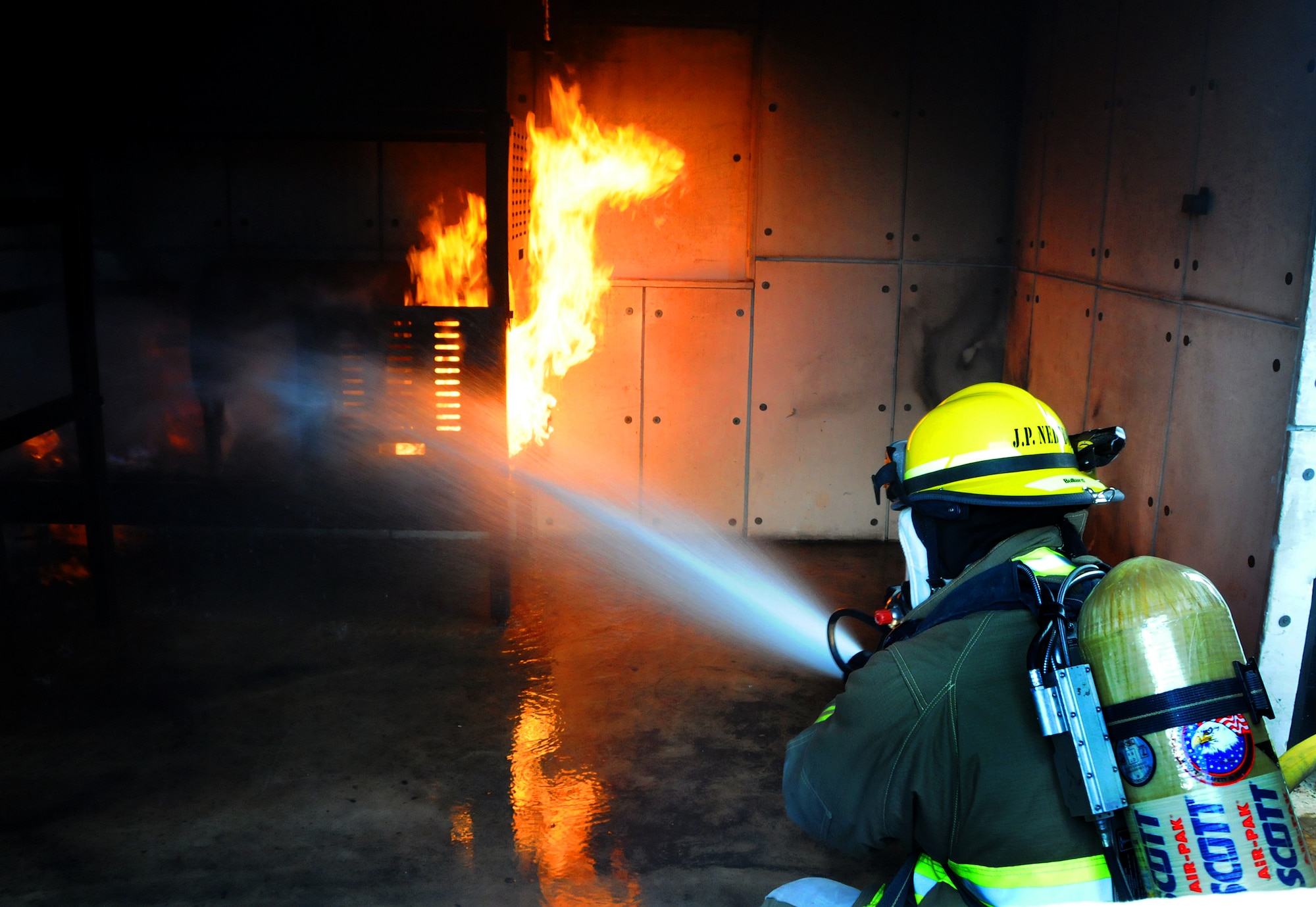 ANDERSEN AIR FORCE BASE, Guam - Yigo firefighter Roy Siongco puts out a fire during a joint training mission with Department of Defense, Government of Guam and Guam International Airport fire departments here Jan 22. Firefighters must be able to think clearly, critically, and solve problems quickly under extreme stressful situations--joint training experiences help to hone these important skills. (U.S. Air Force photo by Airman 1st Class Courtney Witt)   