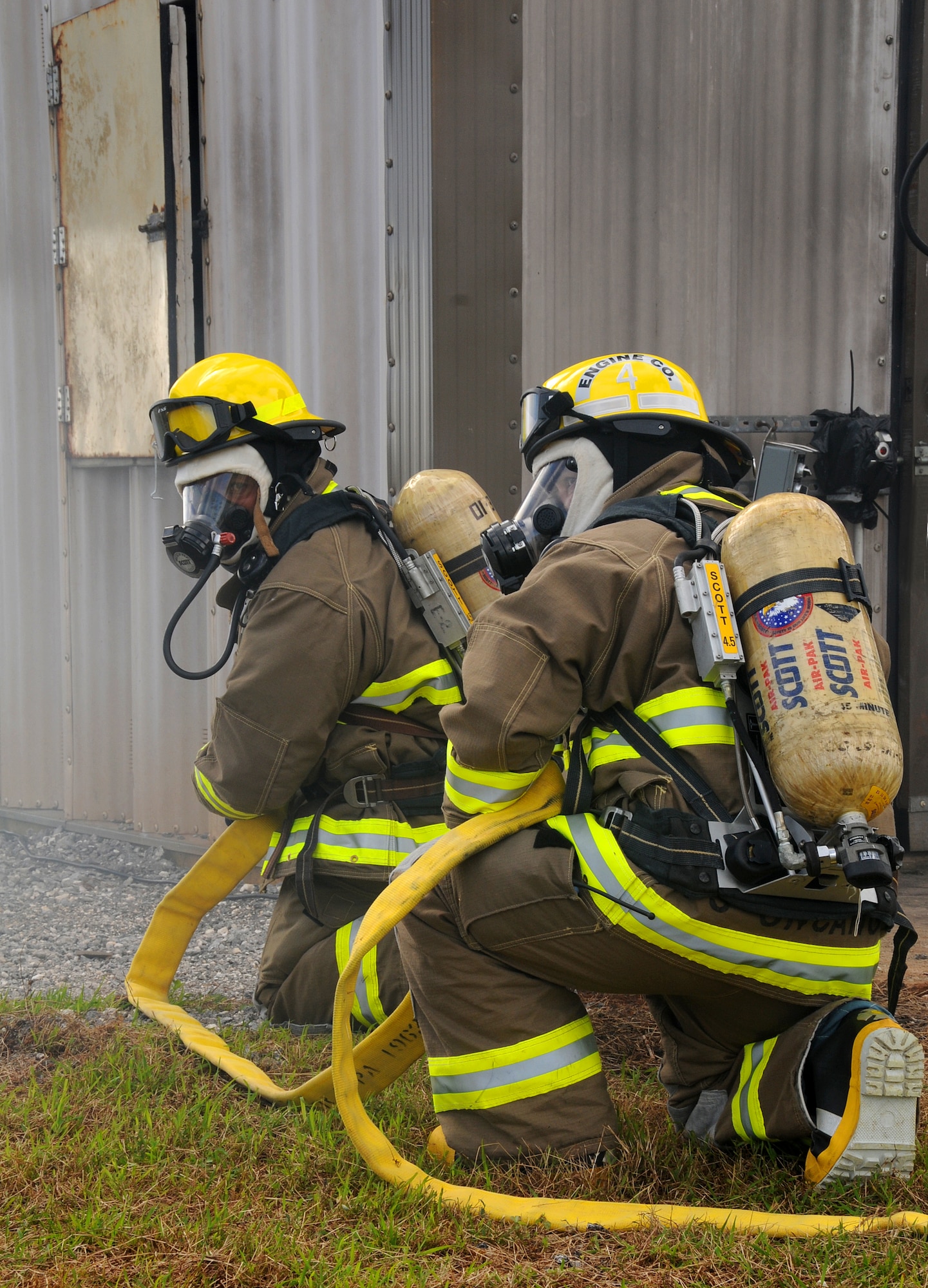 ANDERSEN AIR FORCE BASE, Guam - Yigo firefighters, Roy Siongco and Pascual Uncangco stand ready to enter a burning building here during a joint training with Department of Defense, Government of Guam and Won Pat International Airport fire departments Jan 22. Repeated exposure helps firefighters develop good habits and build tactical strategies that help during real-world scenarios. (U.S. Air Force photo by Airman 1st Class Courtney Witt)