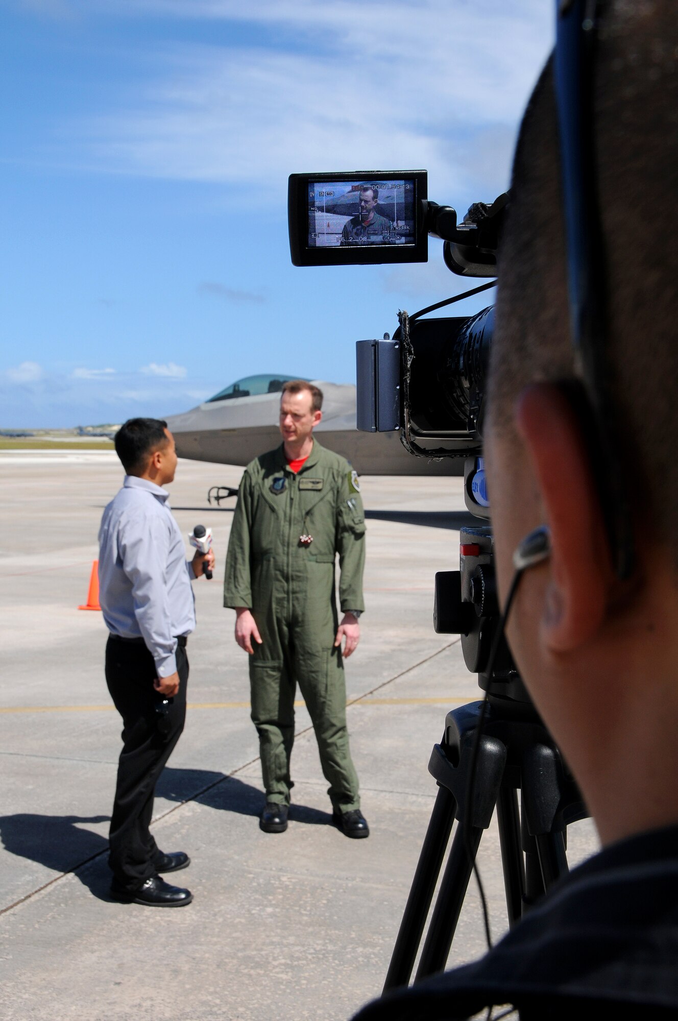 ANDERSEN AIR FORCE BASE, Guam - A camera man for Pacific News Center records an interview with Lt. Col. Chris Niemi, 90th Expeditionary Fighter Squadron Director of Operations, here Jan. 23. Media had the opportunity to conduct an interview with a Colonel Niemi and Staff Sgt. Andrew Fowler, a maintainer, as well as capture video and photo images.  The 90th Expeditionary Fighter Squadron deployed to Andersen with 12 F-22 Raptors. (U.S. Air Force photo by Airman 1st Class Courtney Witt)