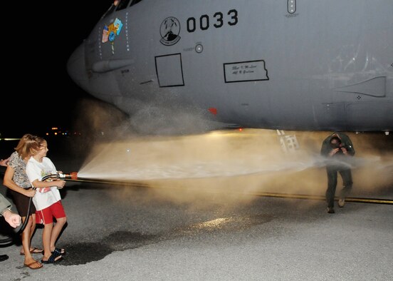 ANDERSEN AIR FORCE BASE, Guam - Col. Gregory Cain 36th Wing Vice commander shields his face as his wife Juilie and son Benjamin spray him down after returning from his final flight here Jan.22. (U.S. Air Force photo by Senior Airman Nichelle Griffiths)