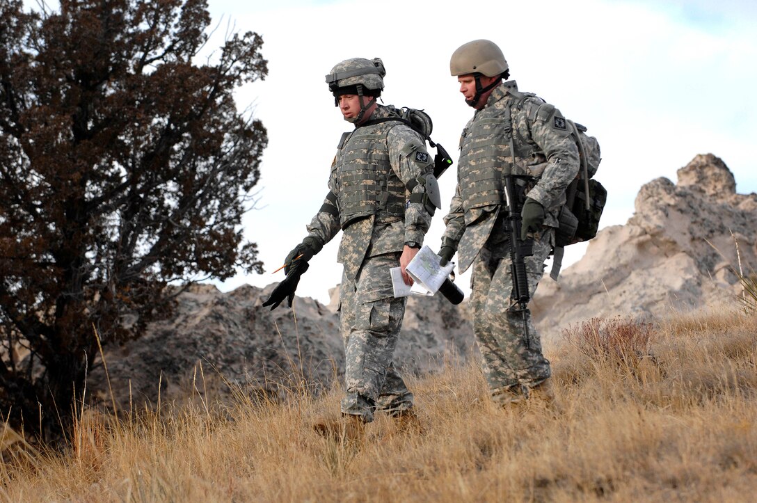 Army Maj. Joe Gallagher, right, and 1st Lt. Alex Wild work their way through a land navigation course at Camp Guernsey, Wyo., Jan. 10, 2009. Both are assigned to the Wyoming Army National Guard’s 115th Fires Brigade, which is scheduled to deploy overseas in April. The site has nearly doubled its size in recent years to accommodate training needs for the state’s units deploying in support of the Global War on Terror.