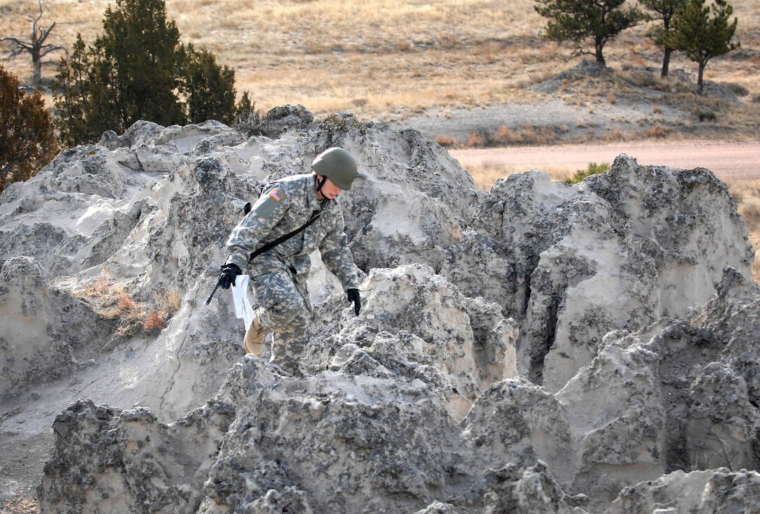 Army Pfc. Katie Farlinger makes her way over the rocky bluffs at the