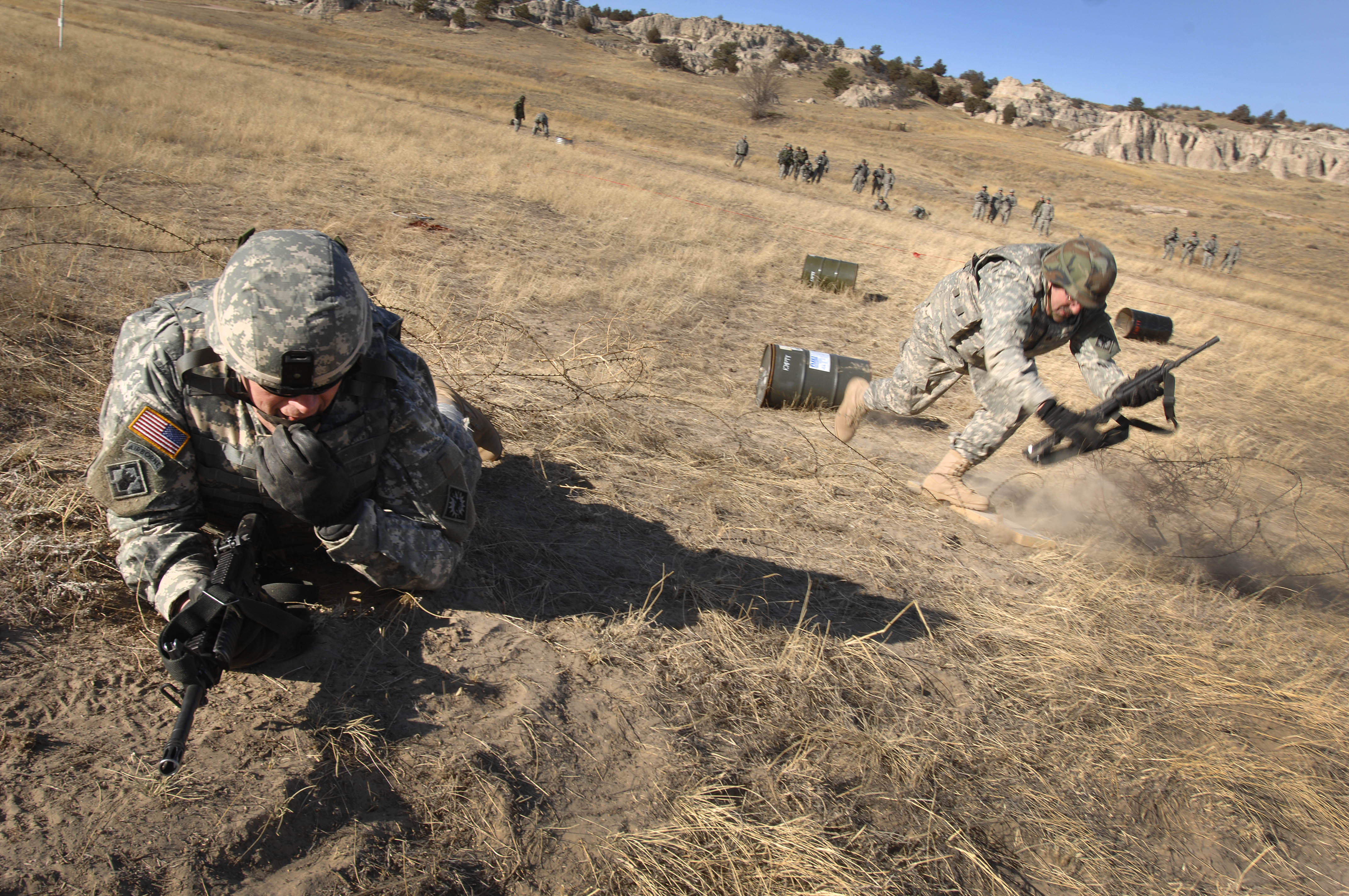Army Sgt. 1st Class Doug Brenneman breaches a concertina wire strand as