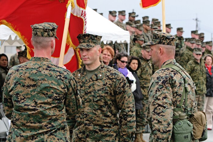 Lt. Col. Douglas S. Mayer passes on the Marine (All-Weather) Attack Squadron 242 colors to Lt. Col. Pappas III during a change-of-command ceremony here Jan 23. Pappas previously served here as the Marine Aircraft Group 12 Headquarters commanding officer.