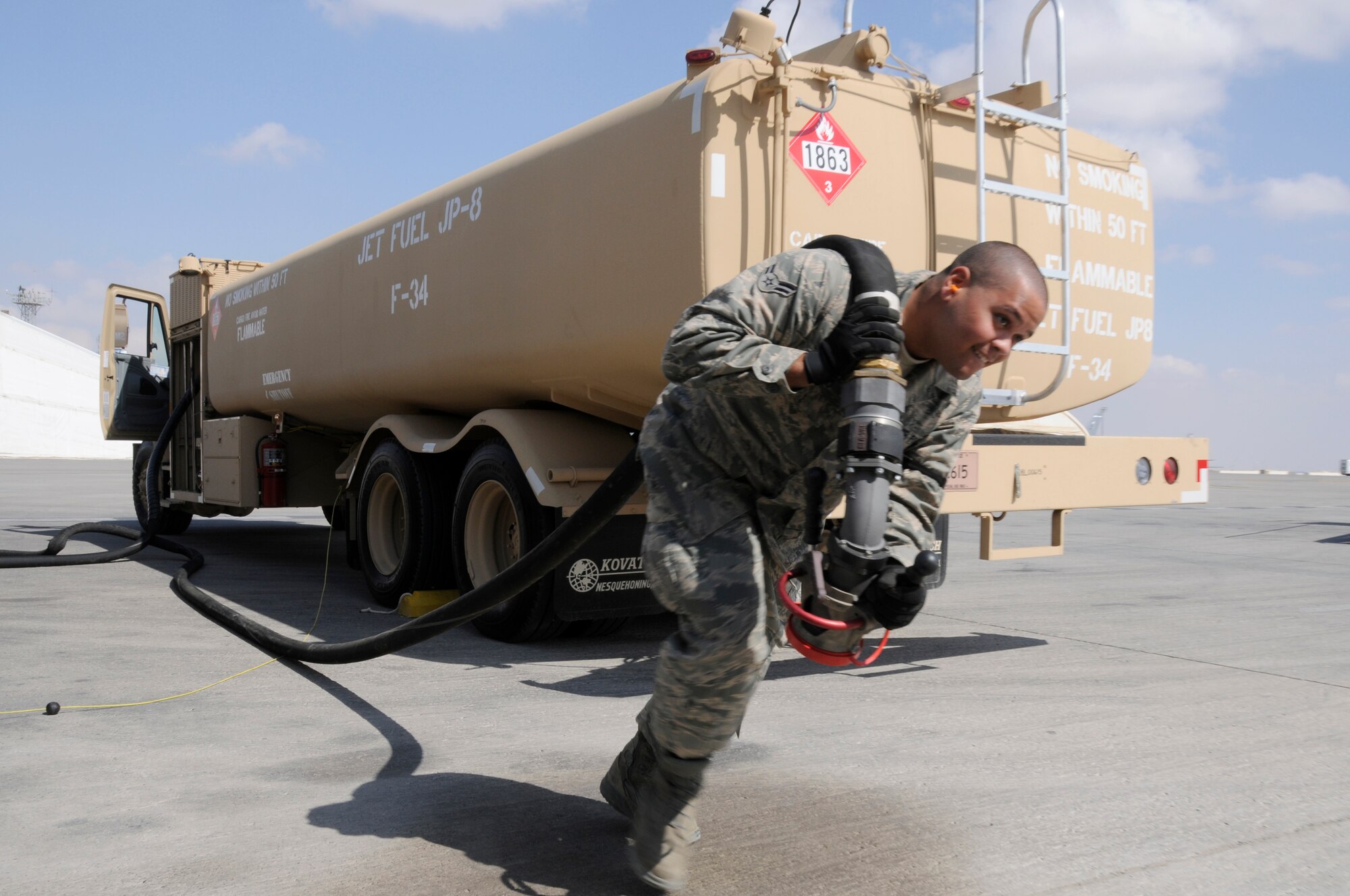 SOUTHWEST ASIA -- Airman 1st Class Eric Castro, 380th Expeditionary Logistics Readiness Squadron fuels operator pulls the hose out to refuel an E-3 Sentry, Jan 21. The 380th is the second largest refueling wing in the Air Force distributing an average of 520,000 gallons a day to aircraft throughout southwest Asia. Airman Castro is deployed from Eglin AFB, Fla. and is from Rochester, N.Y. (U.S. Air Force photo by Senior Airman Brian J. Ellis) (Released)