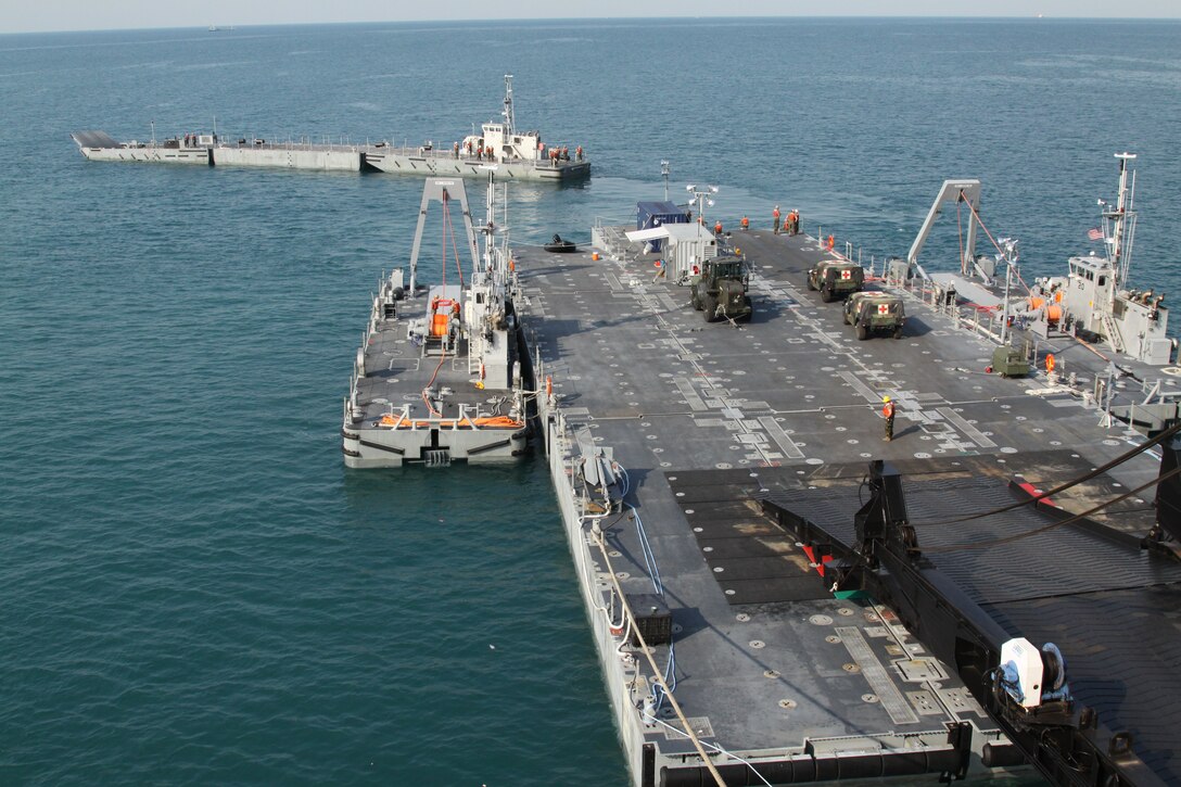 A Navy causeway ferry, top, docks with the USNS Lummus to offload hummvees and other military gear as part of Exercise Freedom Banner on Jan. 25, 2011, Sattahip Navy Base, Thailand. Exercise Freedom Banner utilizes a Maritime Prepositioning Force to offload gear in a timely manner that is unique to the U.S. Marine Corps and Navy.
