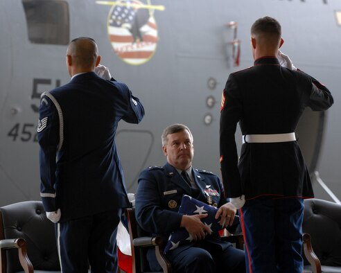 March Field Honor Guard TSgt. Neil Ballacer and Marine Sergeant Kyle Duignan, salute the flag that SGT. Duignan just presented to his father, Maj. Gen. Robert E. Duignan, Commander, 4th Air Force, at the general's retirement ceremony, Jan 25, 2009 at March ARB, Calif.  The general struggled to keep his emotions in check during the presentation.  (U.S. Air Force courtesy photo) (released)