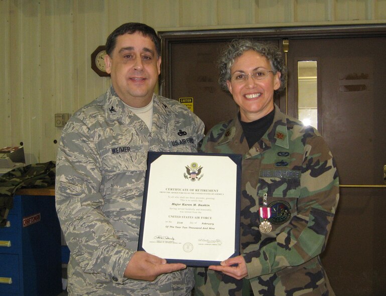 SEYMOUR JOHNSON AIR FORCE BASE, N.C. -- Maj. Karen Baskins (right) receives her certificate of retirement from Col. Paul Weimer during the January unit training assembly. Baskins, a maintenance officer, retired with 20 years of service. Col. Weimer is the commander of the 916th Maintenance Group.