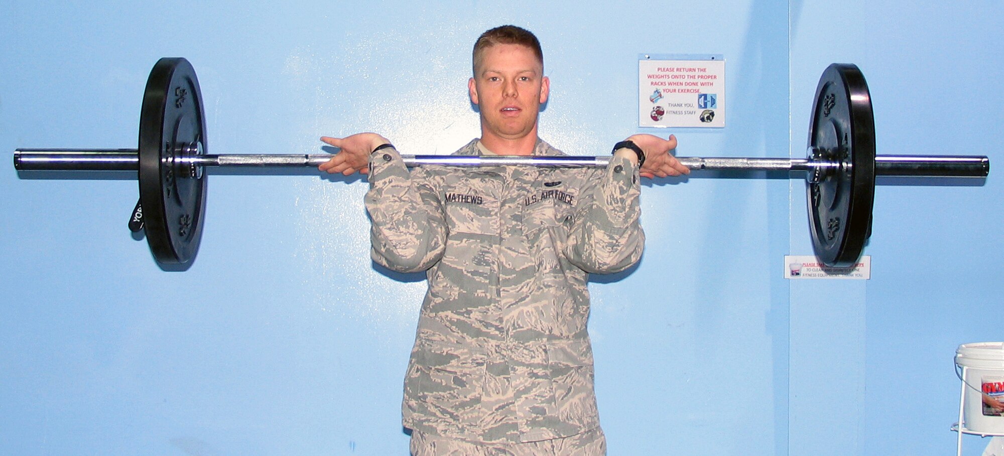 SOUTHWEST ASIA -- Airman 1st Class Joshua Mathews, 386th Expeditionary Force Support Squadron fitness specialist, demonstrates the push press at the Rock Gym. Airman Mathews provides personal training services, teaches circuit training classes and works the gym's front desk. (U.S. Air Force courtesy photo)