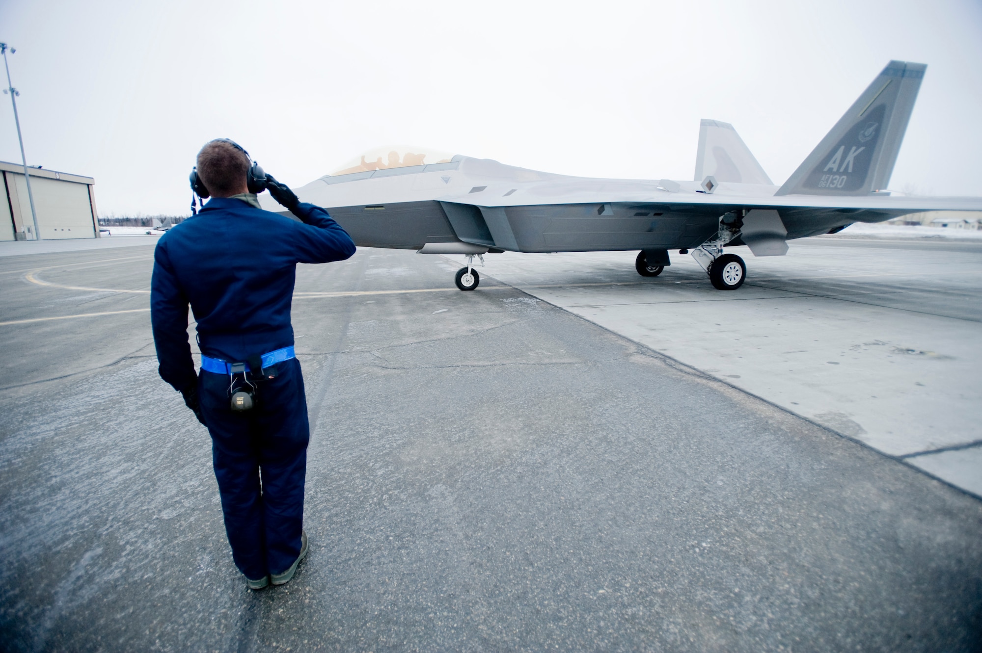 ELMENDORF AIR FORCE BASE, Alaska-- Airman First Class Spencer Parker, 3rd Aircraft Maintenance Squadron, sends an F-22 Raptor from the 525th Fighter Squadron on its way to Nellis Air Force Base for Red Flag Jan. 23. Red Flag is an aerial combat training exercise designed to provide a realistic training environment for U.S. military branches and allies (U.S. Air Force photo/Senior Airman Jonathan Steffen)