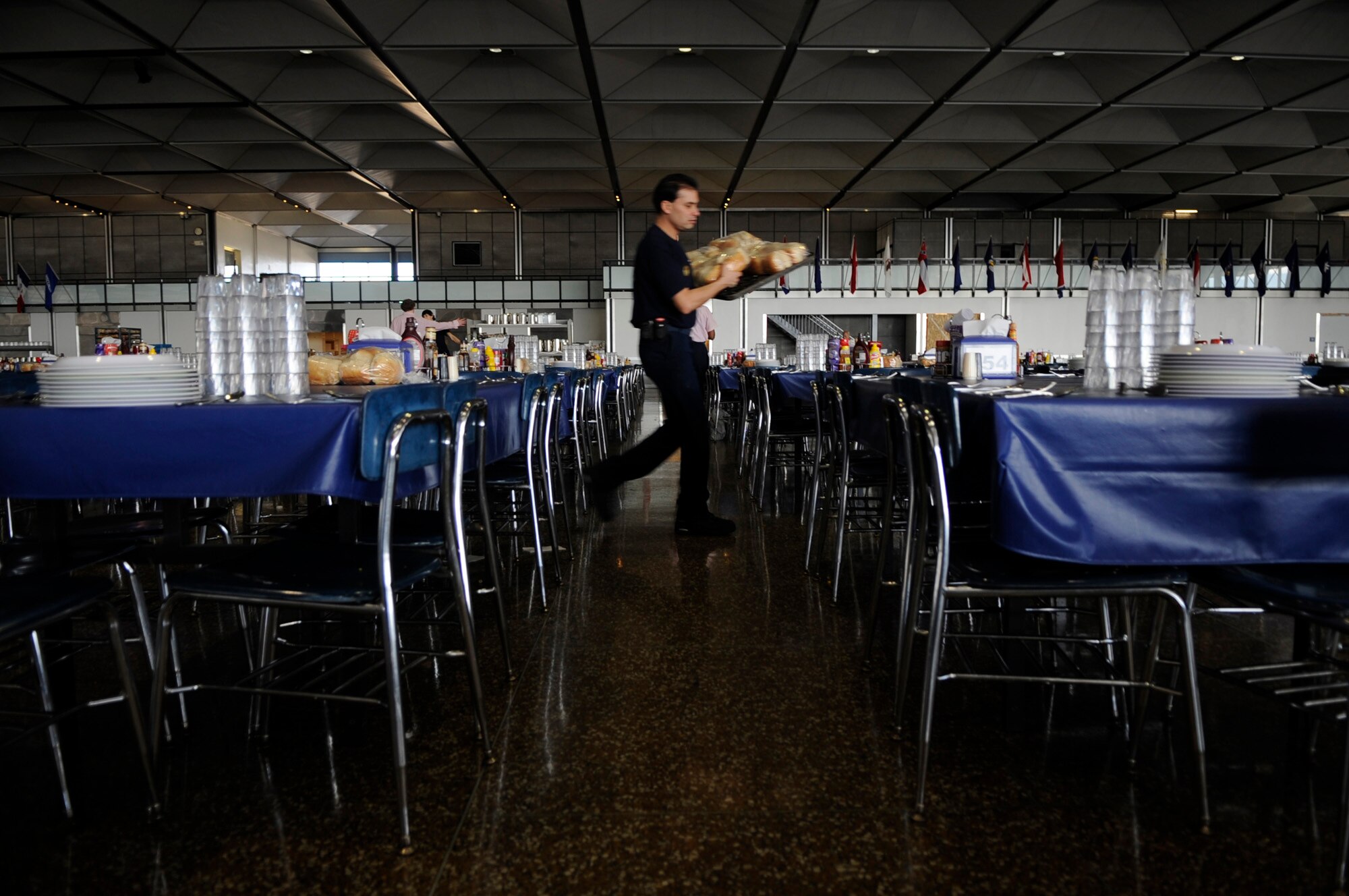 Izzy Colon puts bread on tables in preparation for lunch Jan. 23 at Mitchell Hall Cadet Dining Facility at the U.S. Air Force Academy in Colorado Springs, Colo. The dining facility feeds approximately 4450 cadets and sits on 1.75 acres. (U.S Air Force photo/Staff Sgt. Desiree N. Palacios)